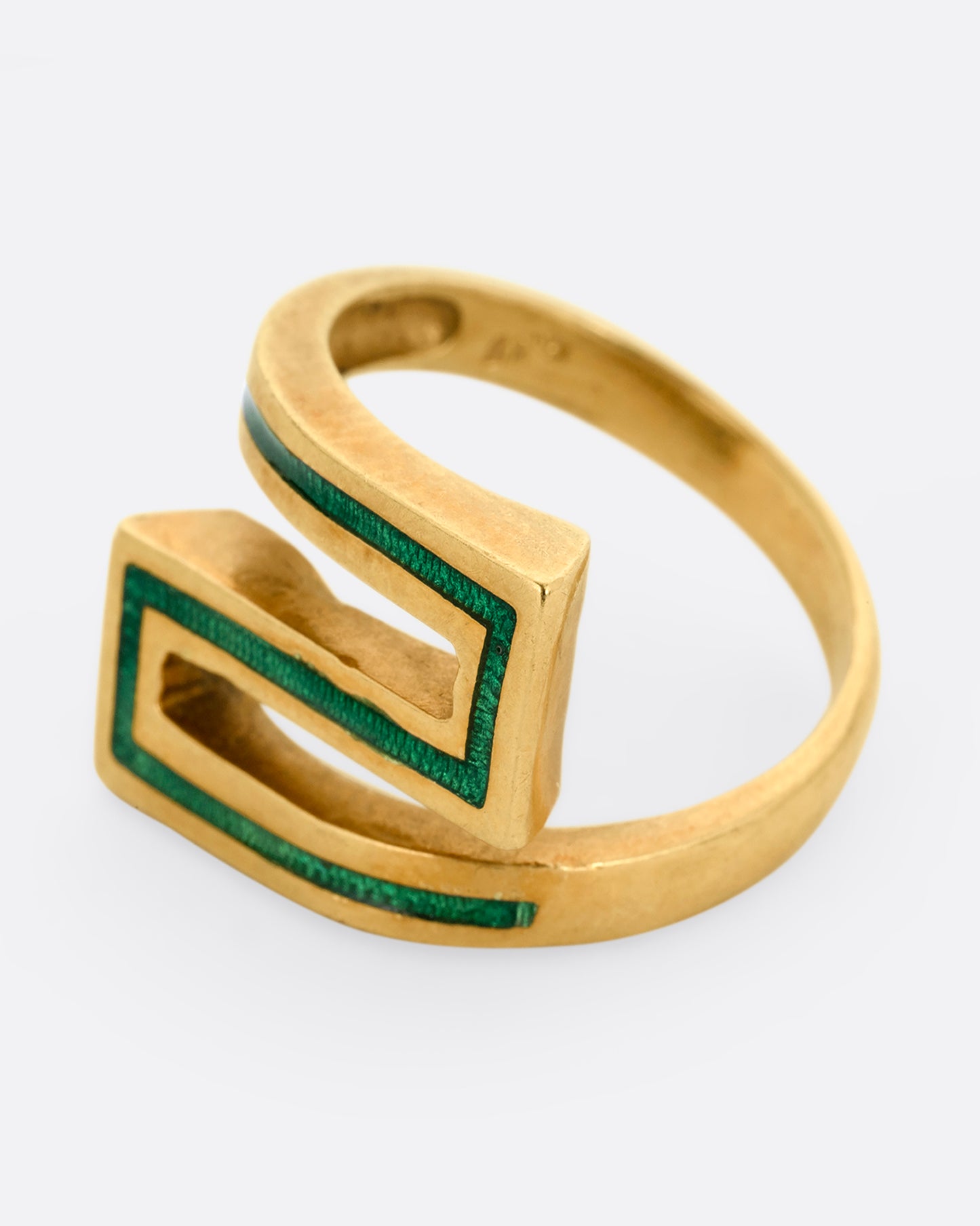A yellow gold Greek Key ring with a zigzag pattern in green enamel, shown from the side.