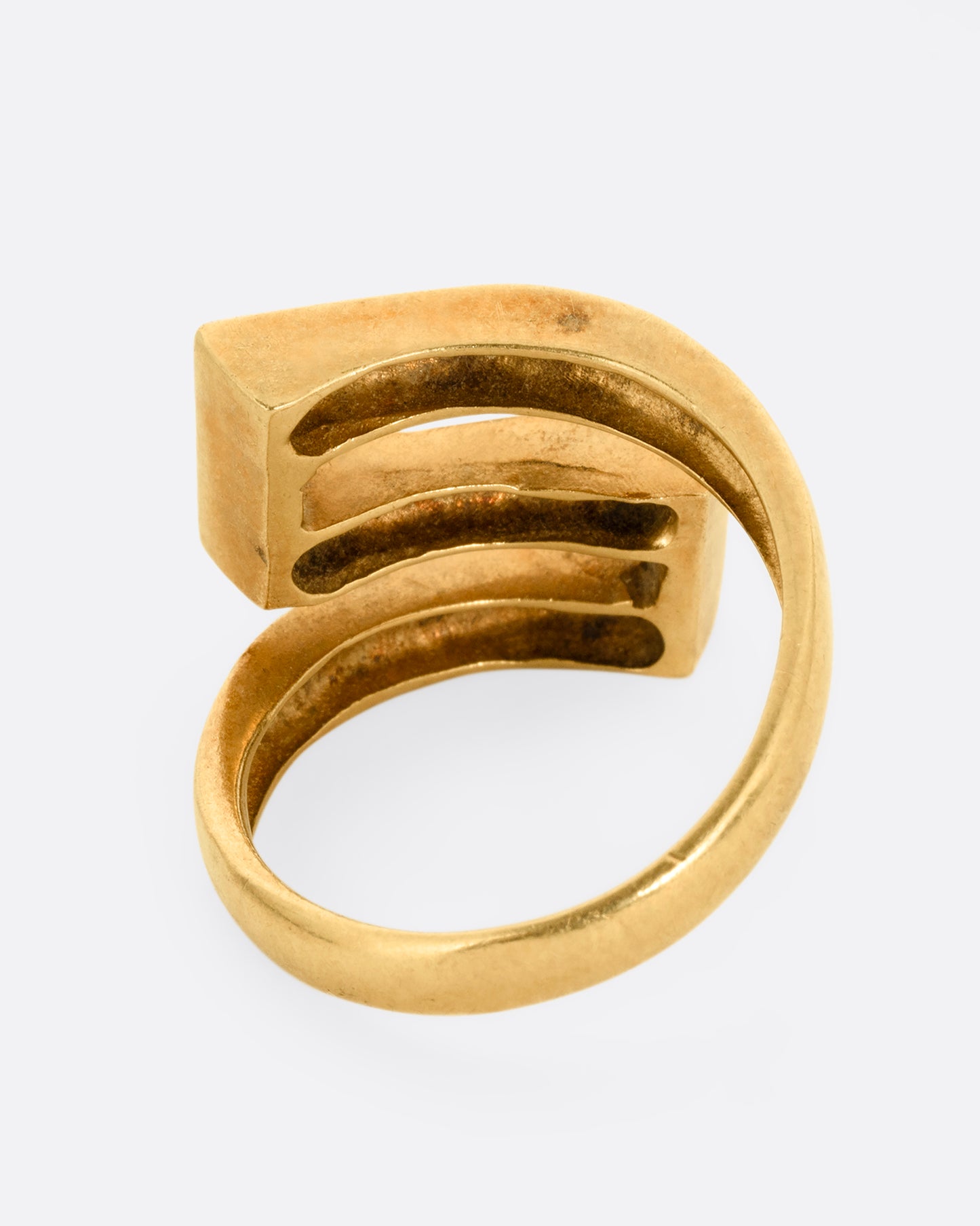 A yellow gold Greek Key ring with a zigzag pattern in green enamel, shown from the back.
