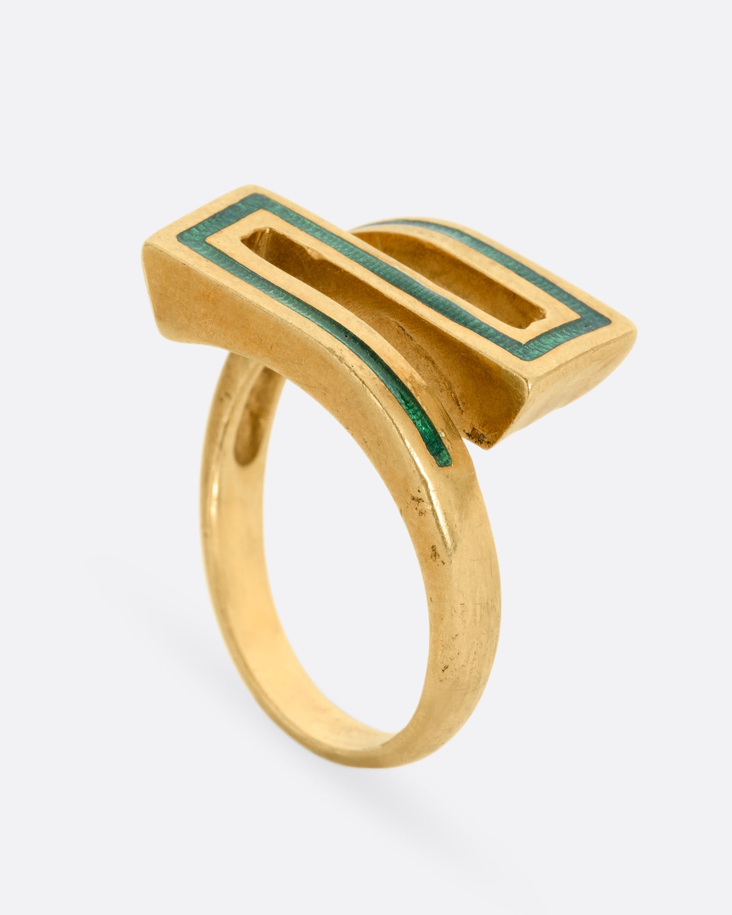 A yellow gold Greek Key ring with a zigzag pattern in green enamel, shown standing up from the side.