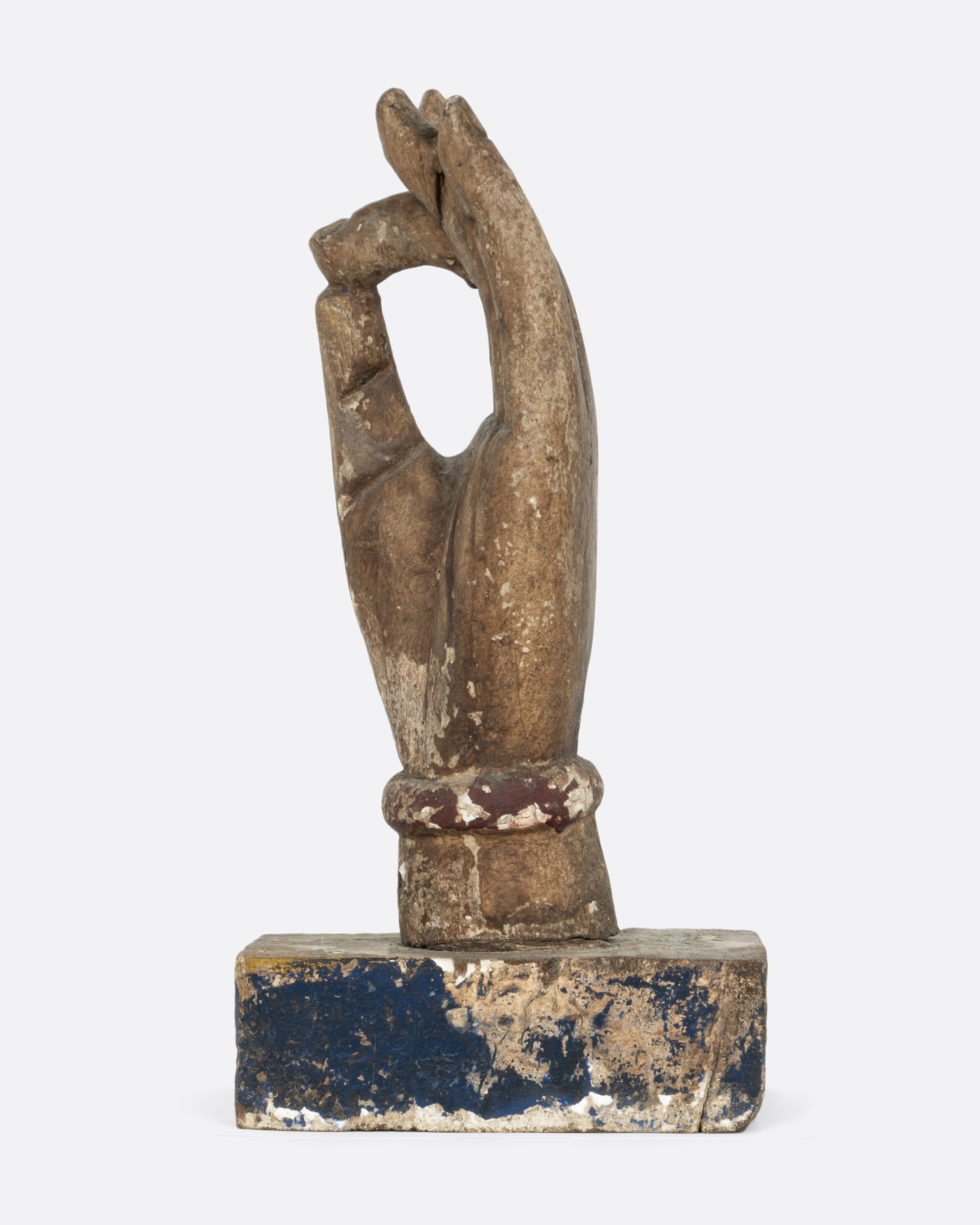 A wooden hand sculpture with the index and thumb touching. Shown from the side.