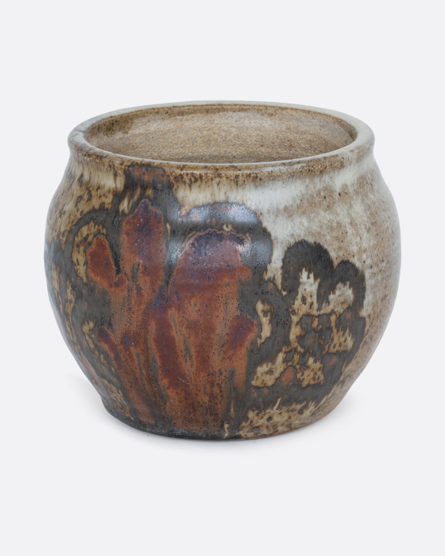 A pot with a brown handpainted pattern of flowers and a drainage hole at its base. Shown from the back.
