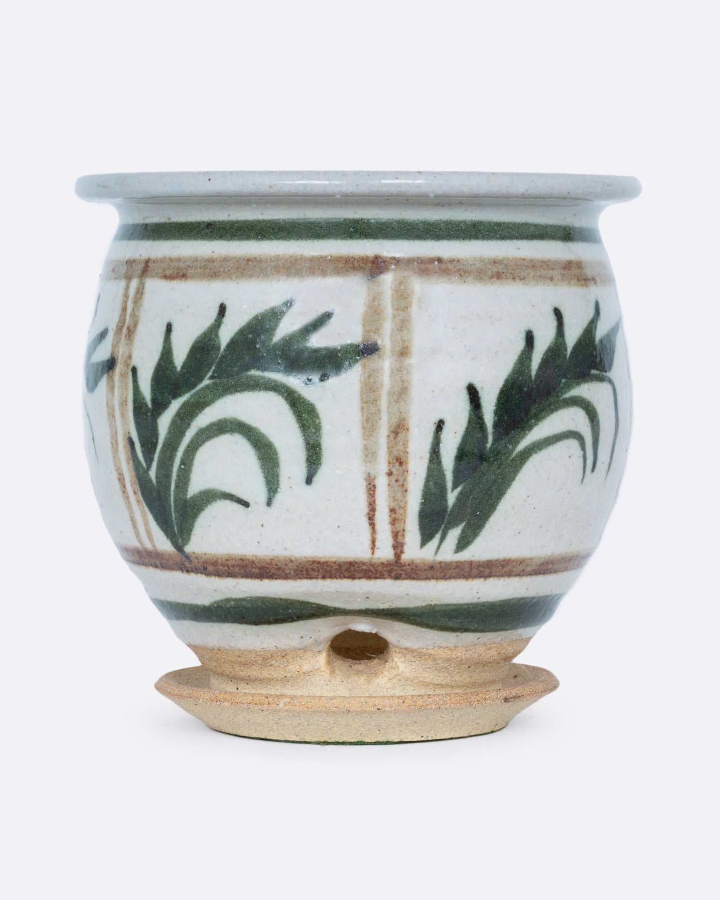 A planter with a hand painted botanical pattern and a drainage hole, water catch, and felted bottom. Shown from the back.
