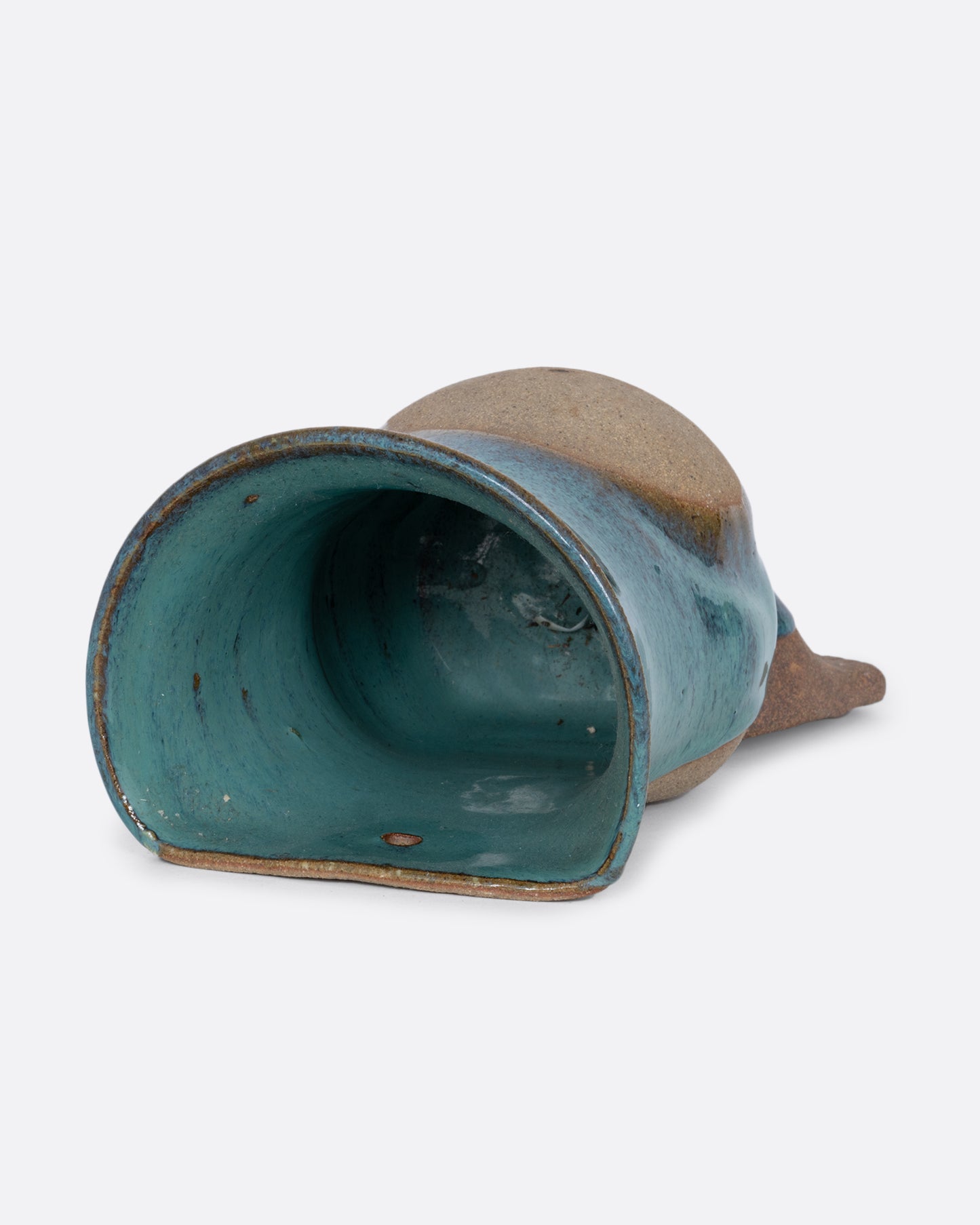 A ceramic wall pocket sculpture of a torso with a belly and feet. Shown lying flat from the top.