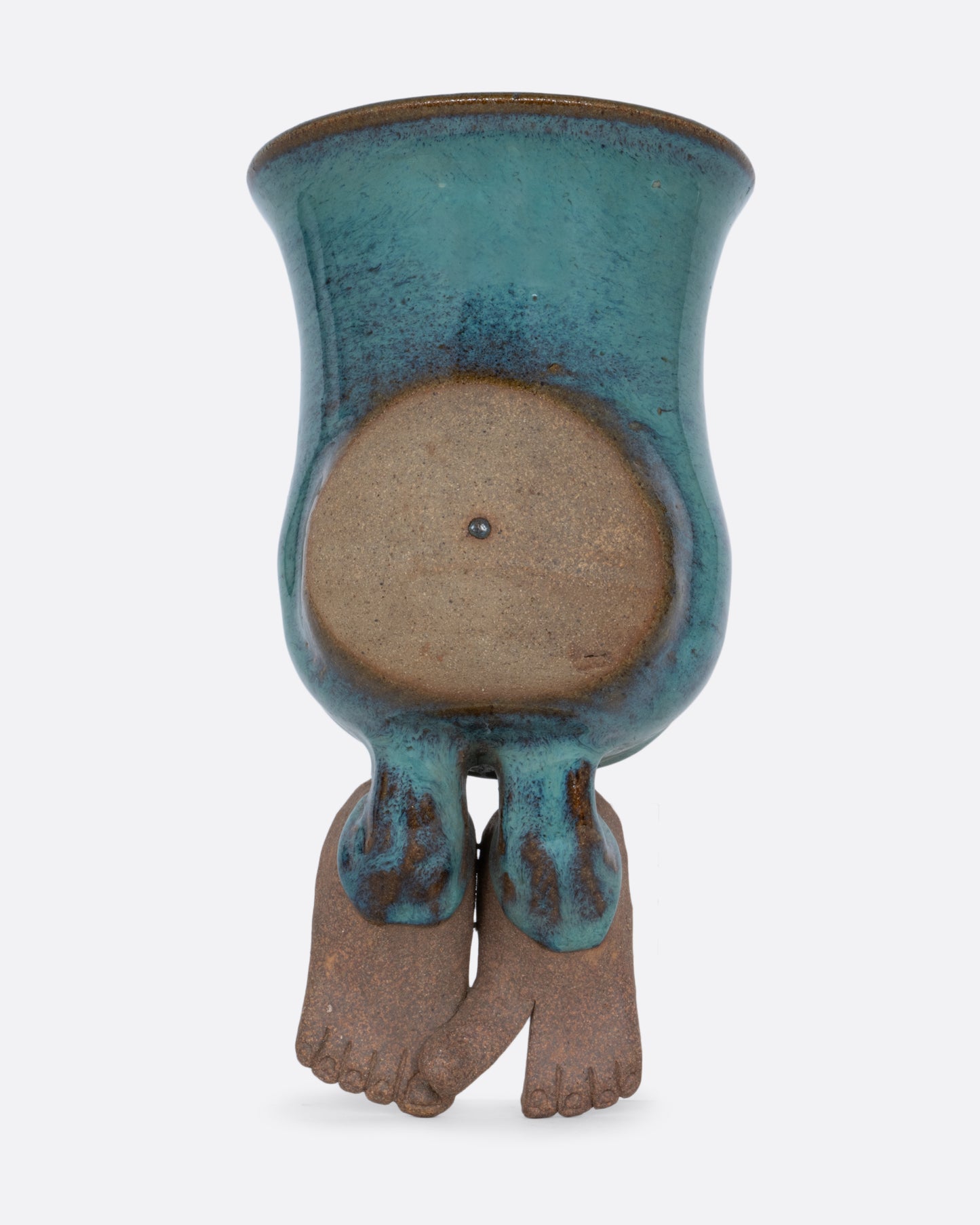 A ceramic wall pocket sculpture of a torso with a belly and feet. Shown from the front.