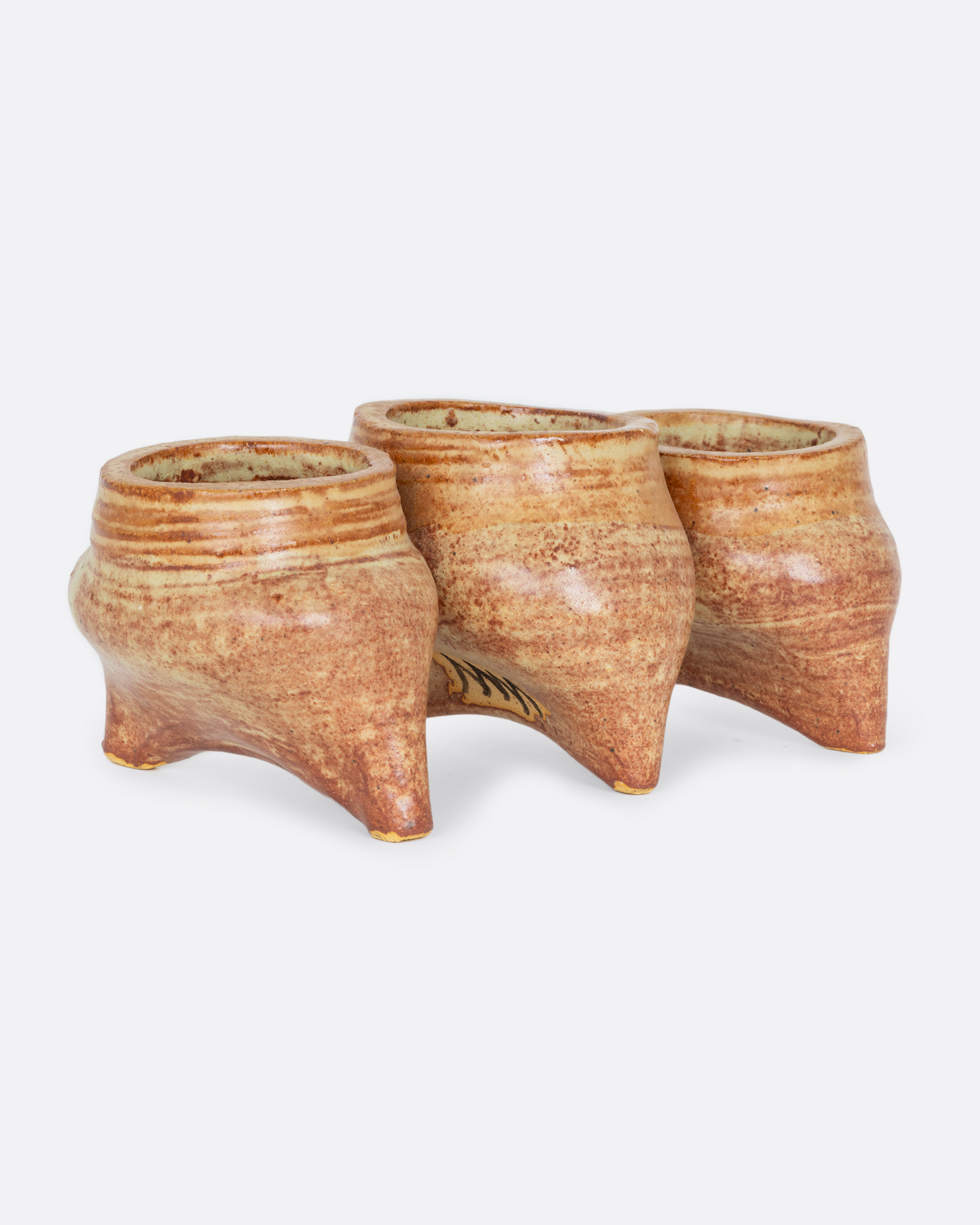 Three connected planters with pinched bottoms, drainage holes, and feet. Shown from the side at an angle.