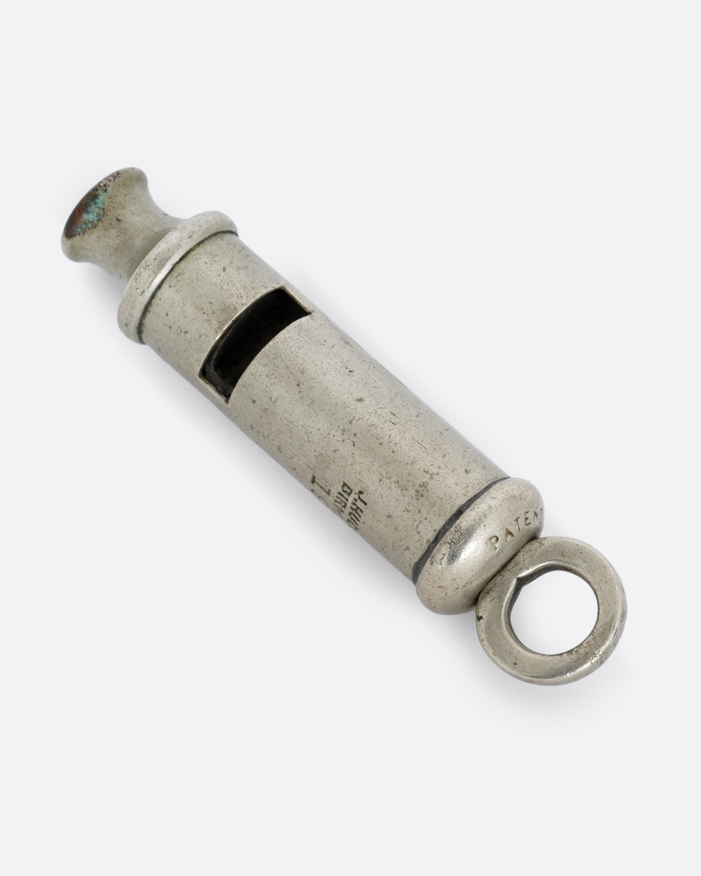 A silver whistle with engraved text, shown from the front.