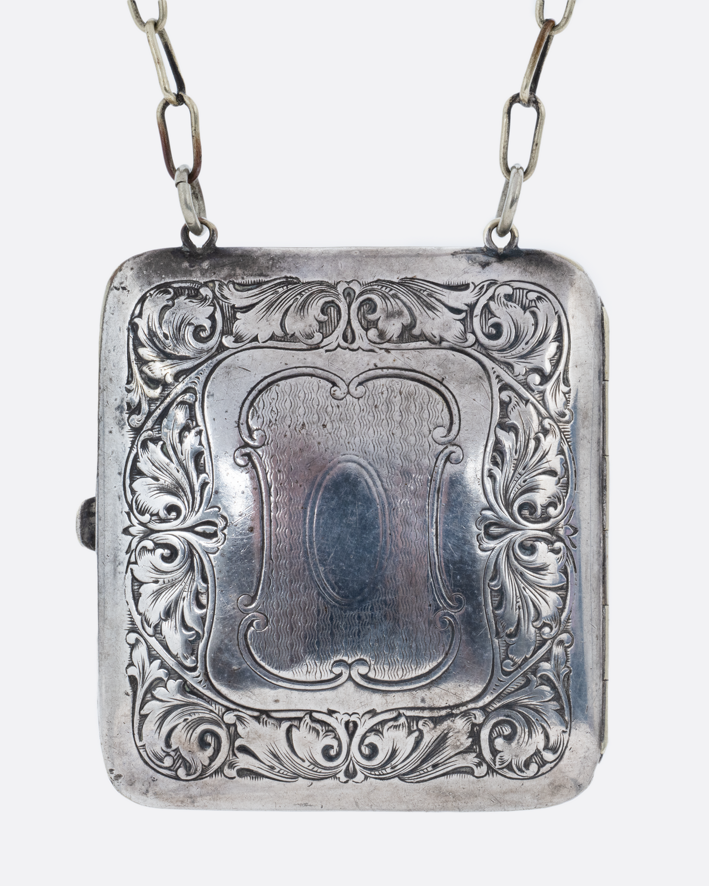 A silver square velvet lined coin purse with a cable wrist chain. Shown from the front.