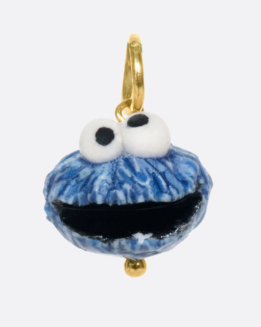 A porcelain Cookie Monster charm on a yellow gold bail.