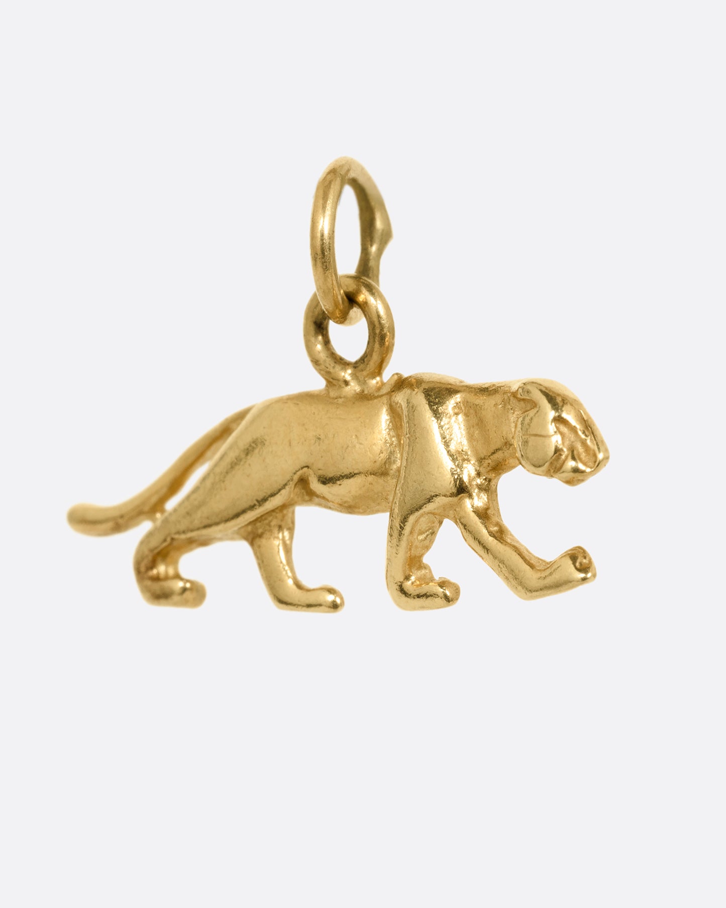 A yellow gold panther charm shown at an angle from the front.