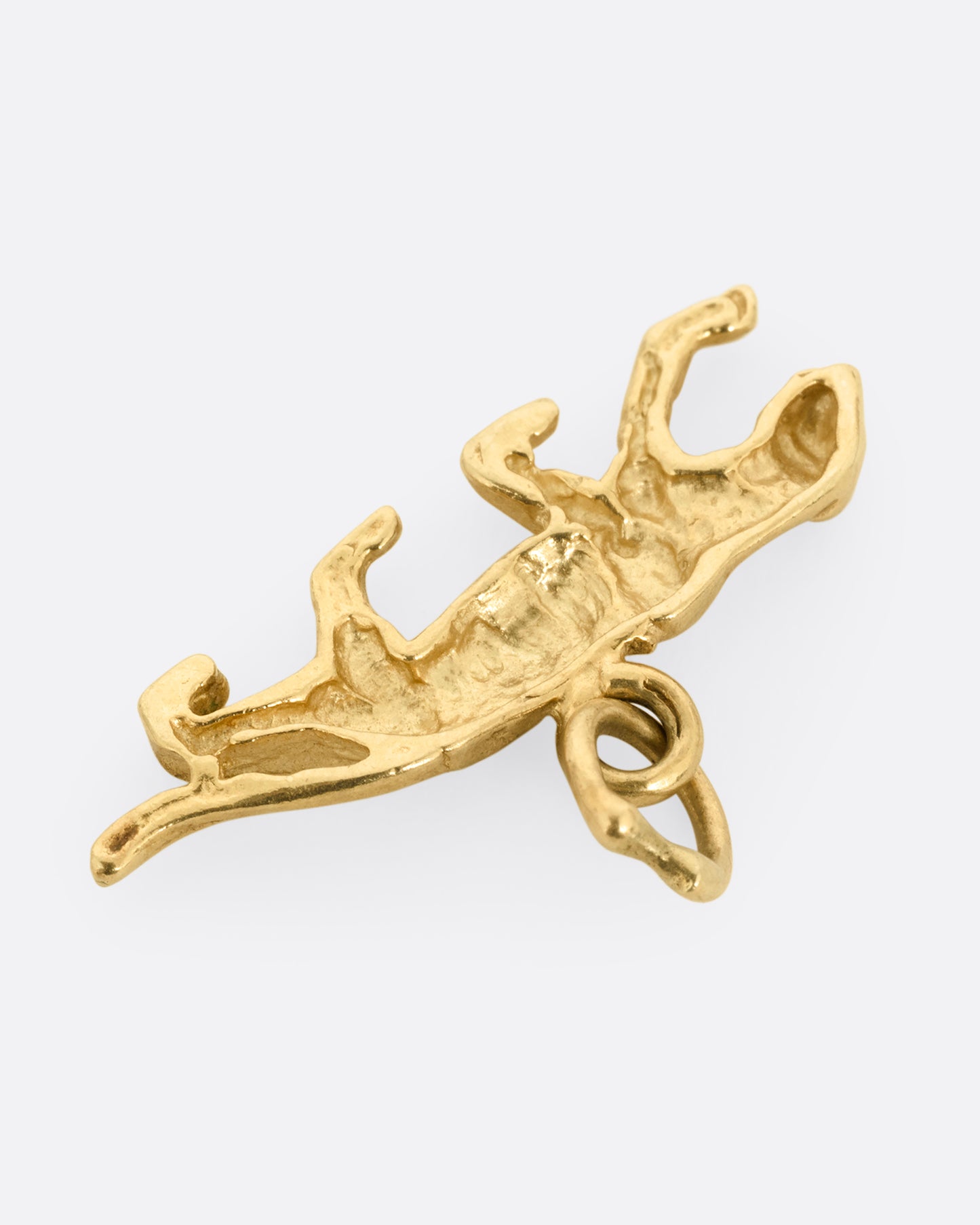 A yellow gold panther charm shown from the back.