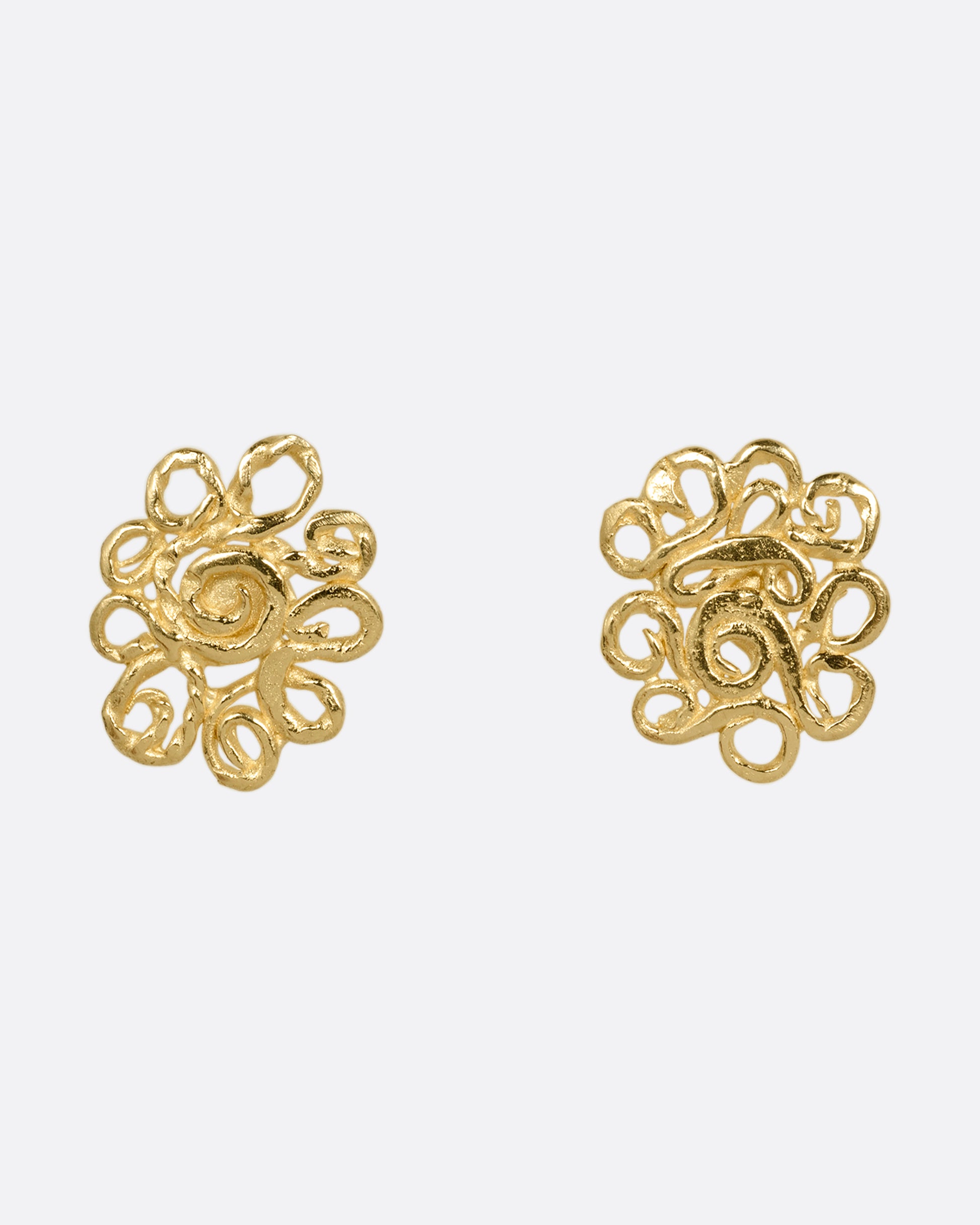 A pair of yellow gold stud earrings with swirling vines in a lacy pattern. Shown from the front.