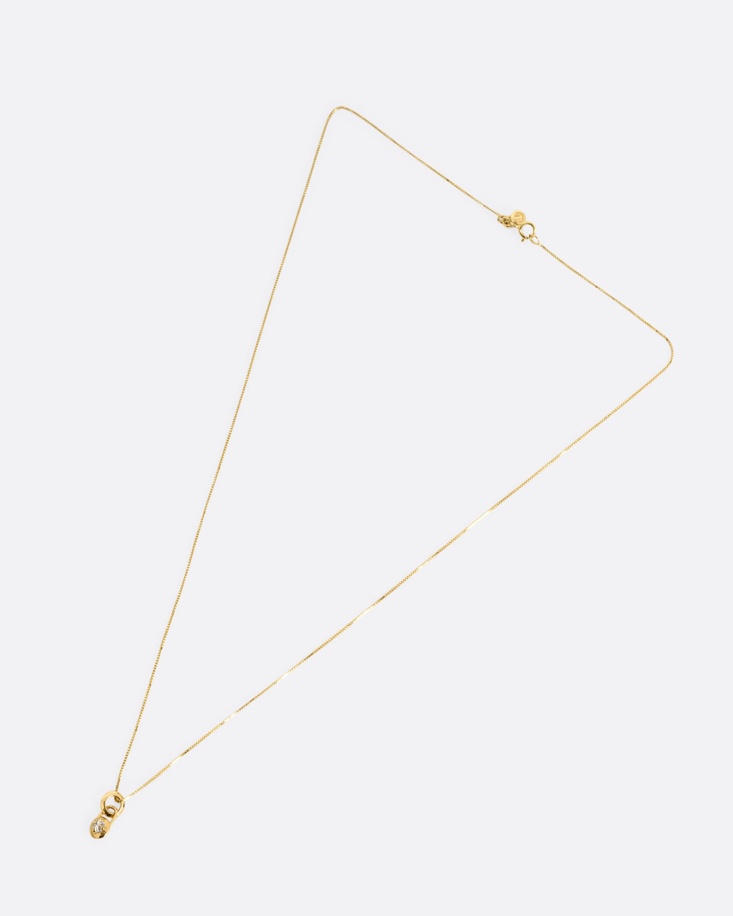 A yellow gold box chain with a padlock shaped pendant. A reverse set diamond is prong set in the center of the pendant. Shown from the front.