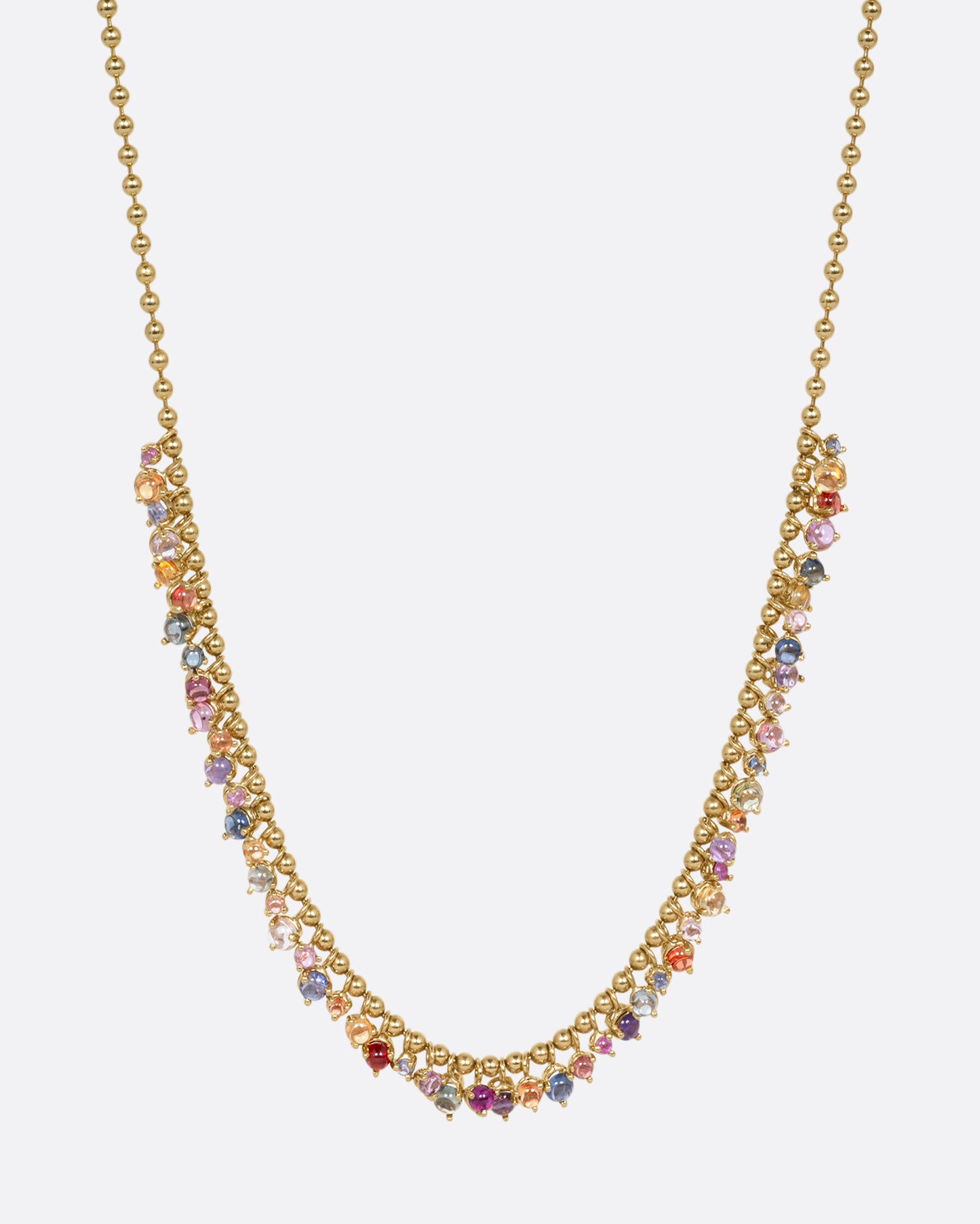 A yellow gold ball chain necklace with many multicolored sapphire dangles. Shown from the front.