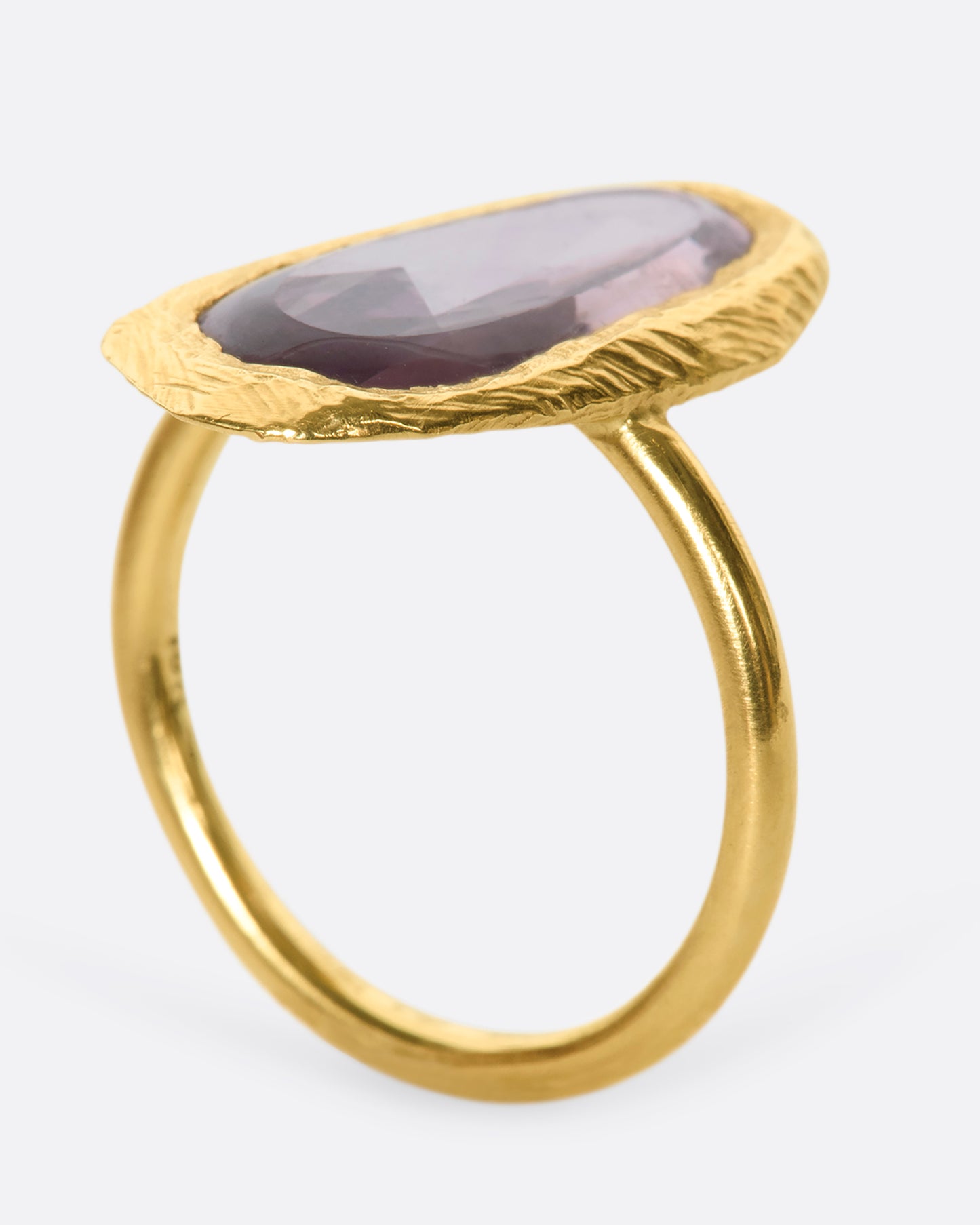 This truly unique freeform, rose-cut purple sapphire is nestled in a hand-carved 18k gold bezel setting