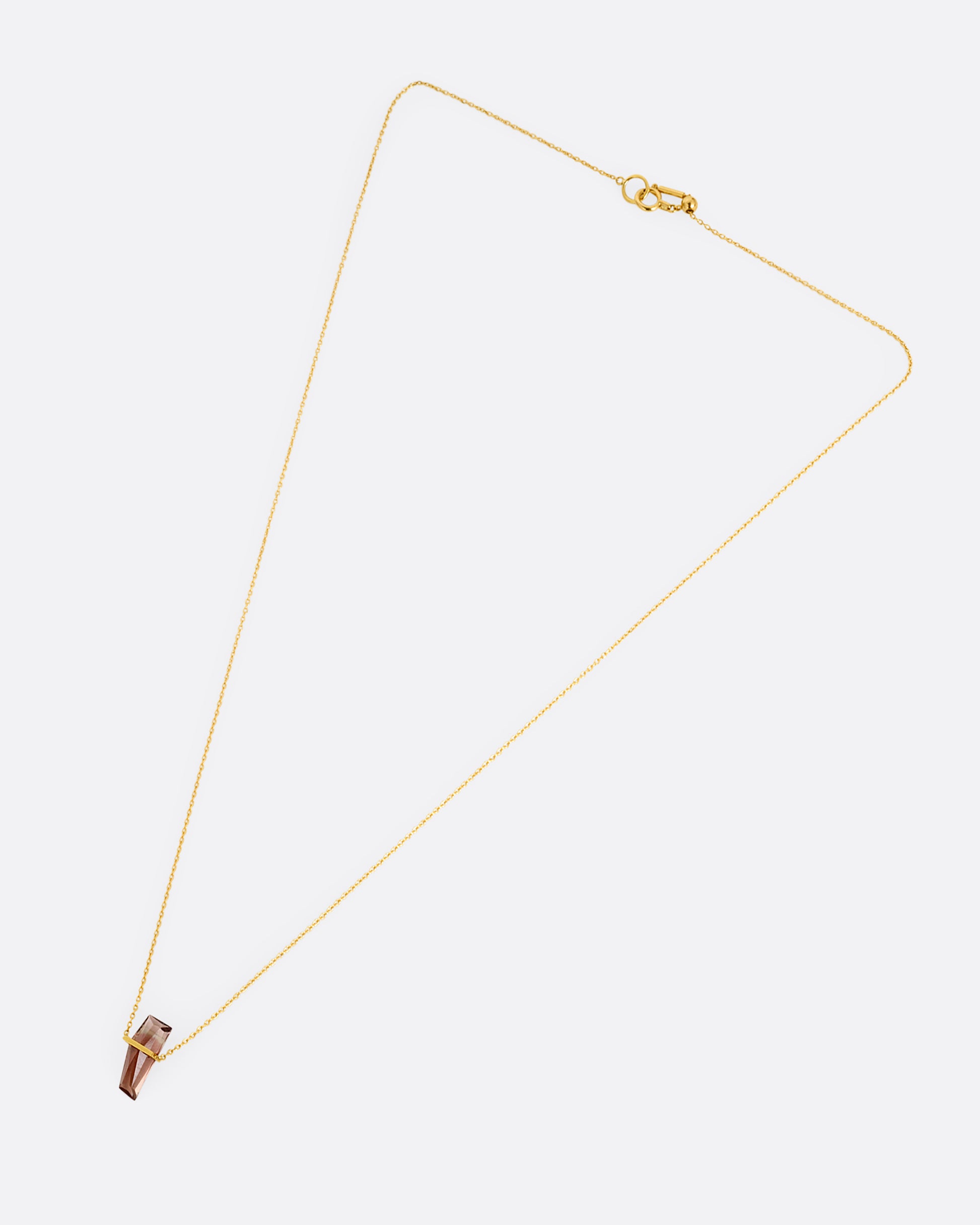A yellow gold cable chain necklace with a five sided rosy quartz in an open bar setting. Shown from the front.