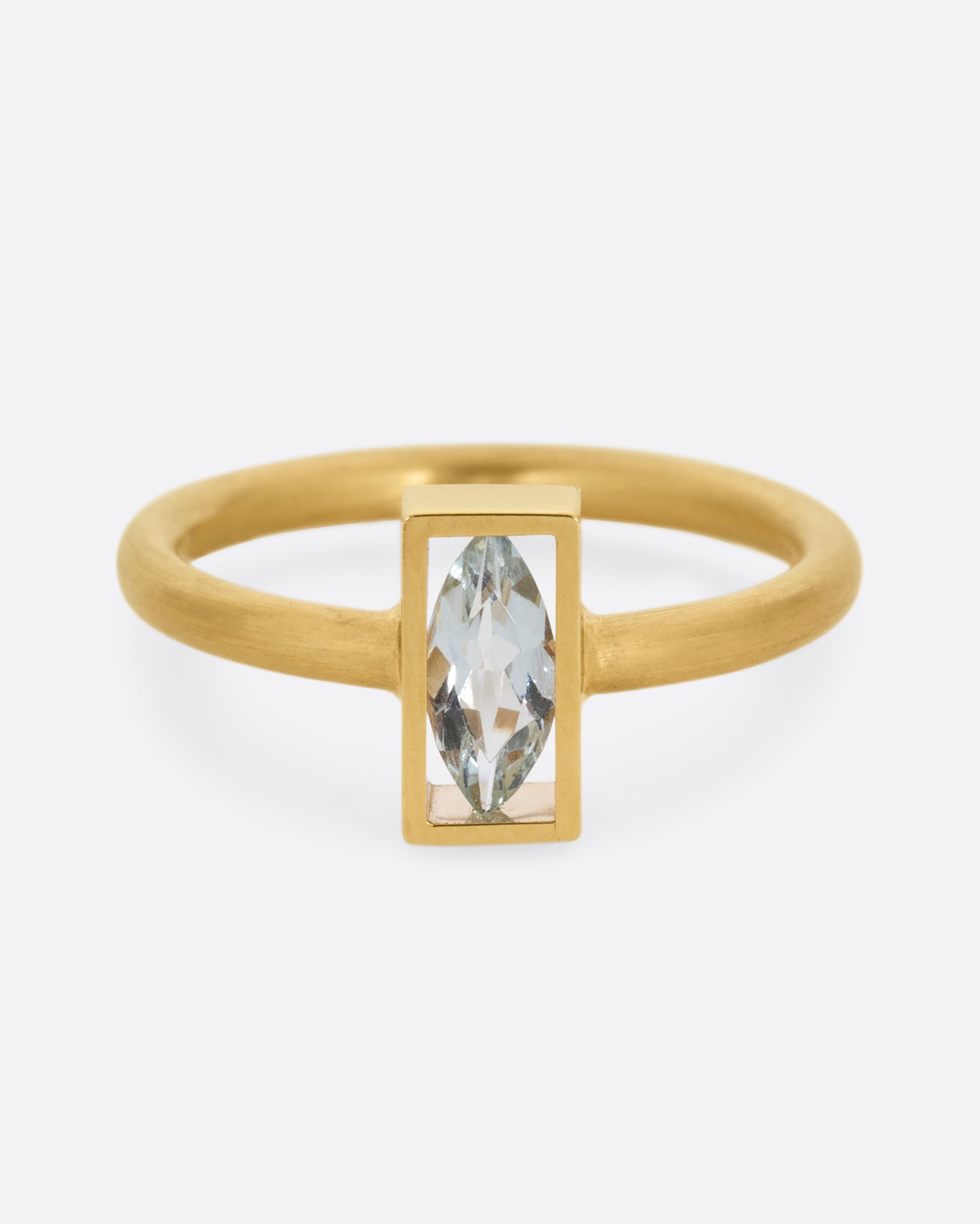 A yellow gold ring with an aquamarine in an open rectangular setting. Shown from the front.