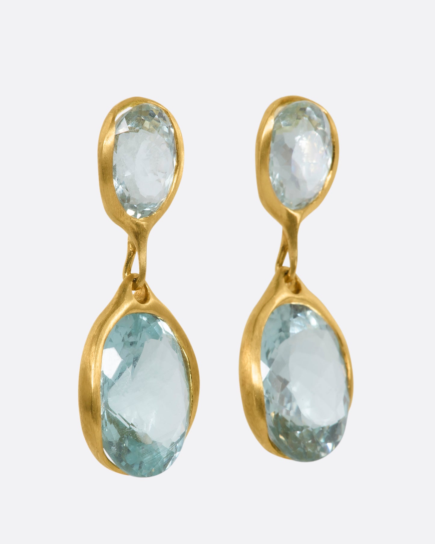A pair of yellow gold aquamarine stud double drop earrings. View from the side.