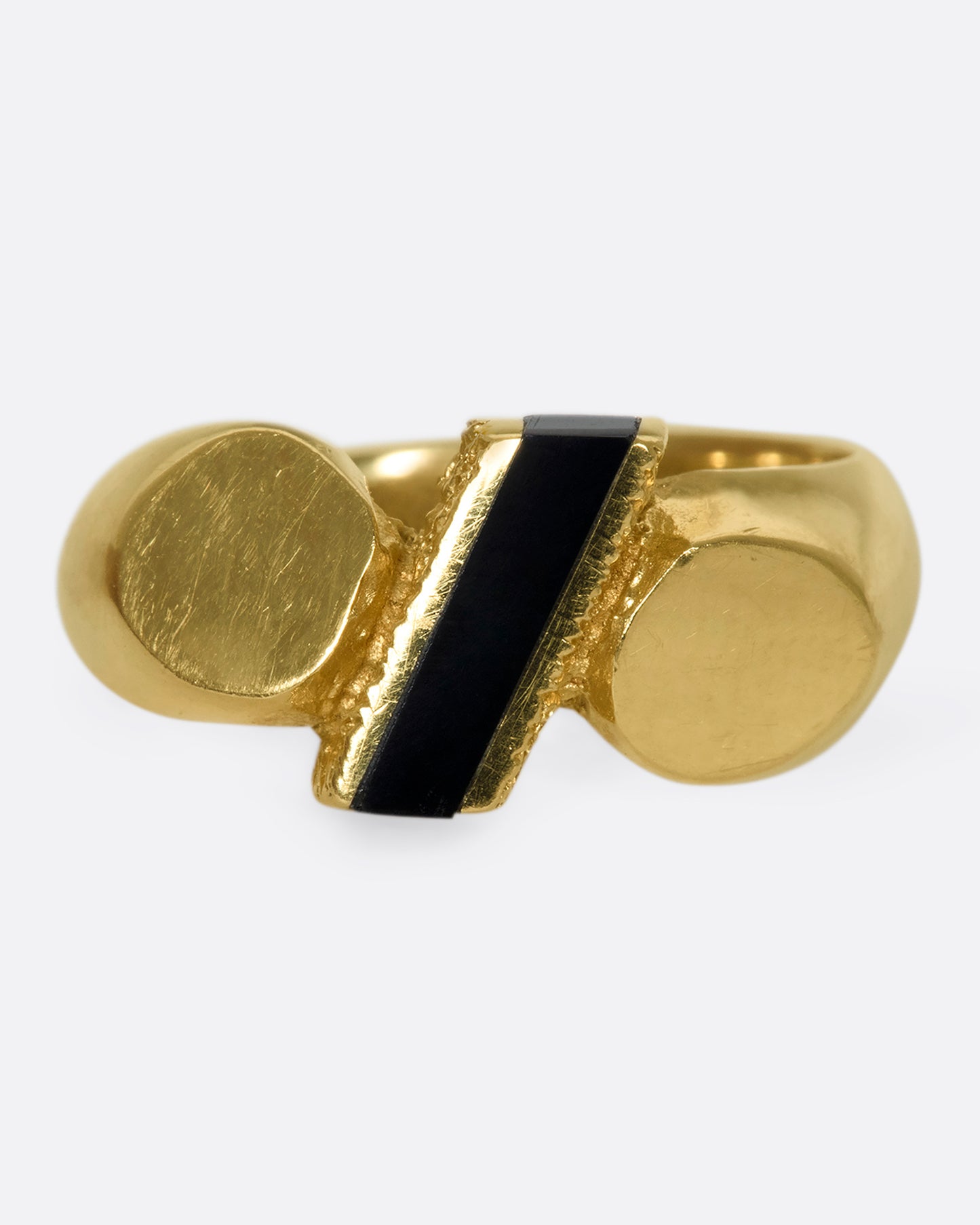 A vintage 14k gold puffy, rounded band with flat ends and a slice of onyx popping through the center