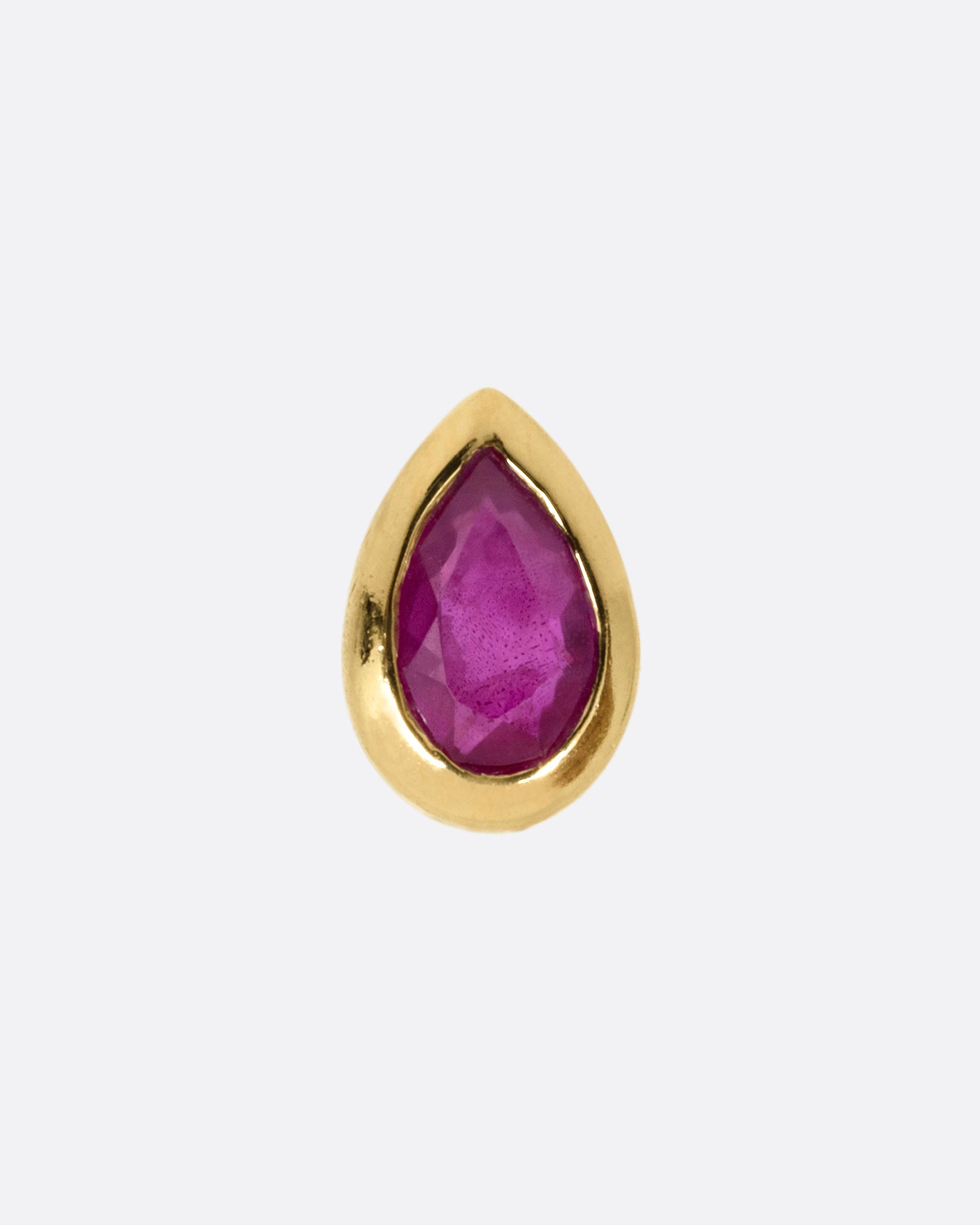 A yellow gold stud earring with a pear shaped ruby, shown from the front.