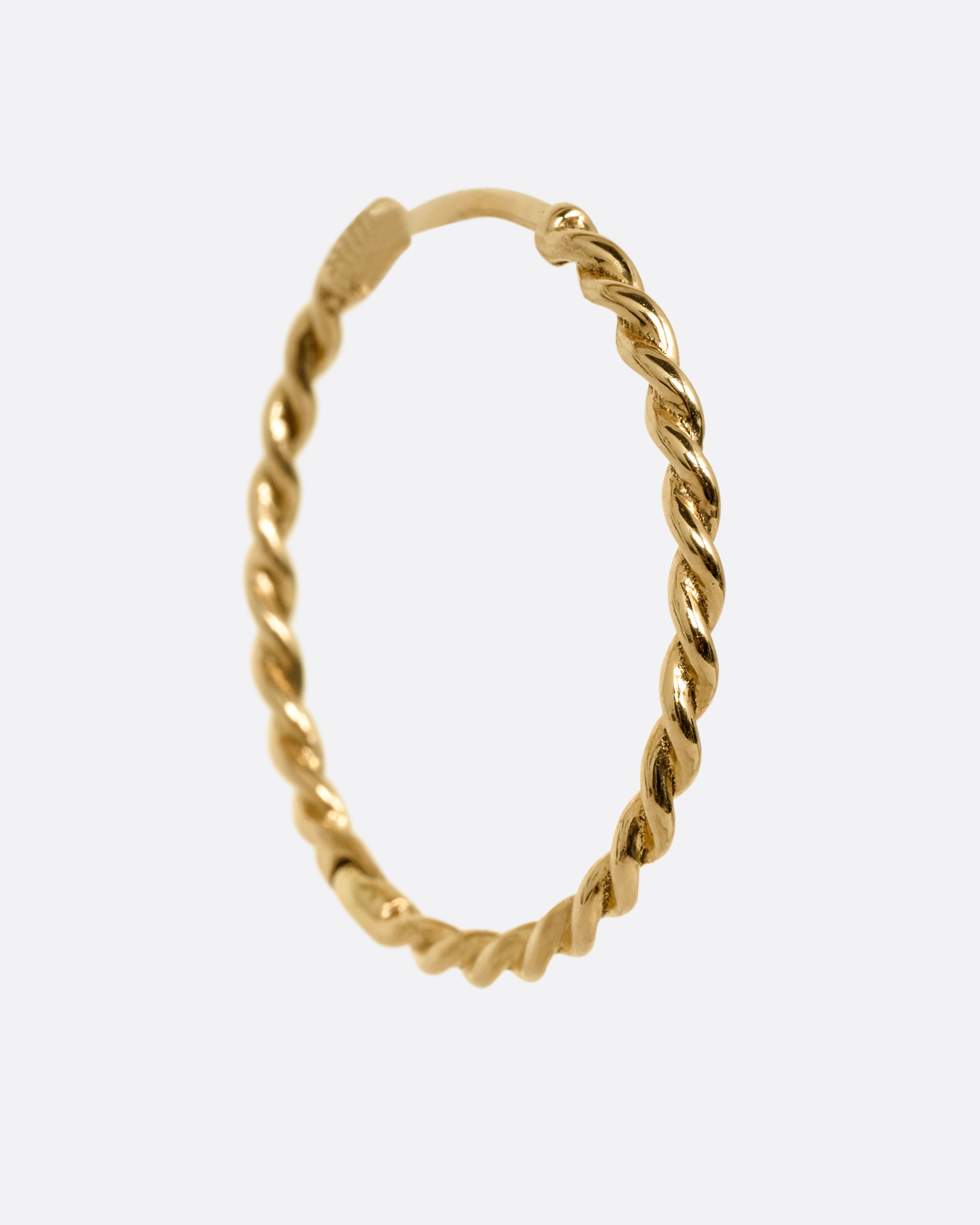 A yellow gold twisted hoop earring with a clicker clasp, shown from the side.