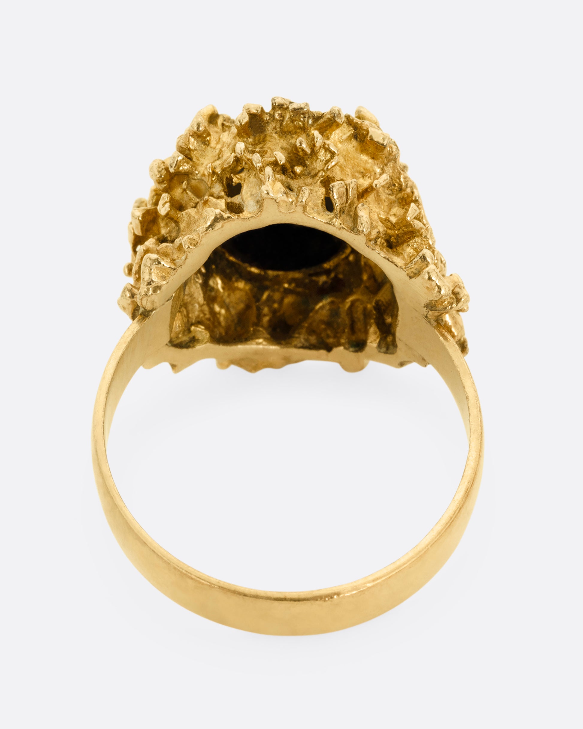 A yellow gold Brutalist era statement ring with an opal doublet in a molten gold nest. Shown from the back.