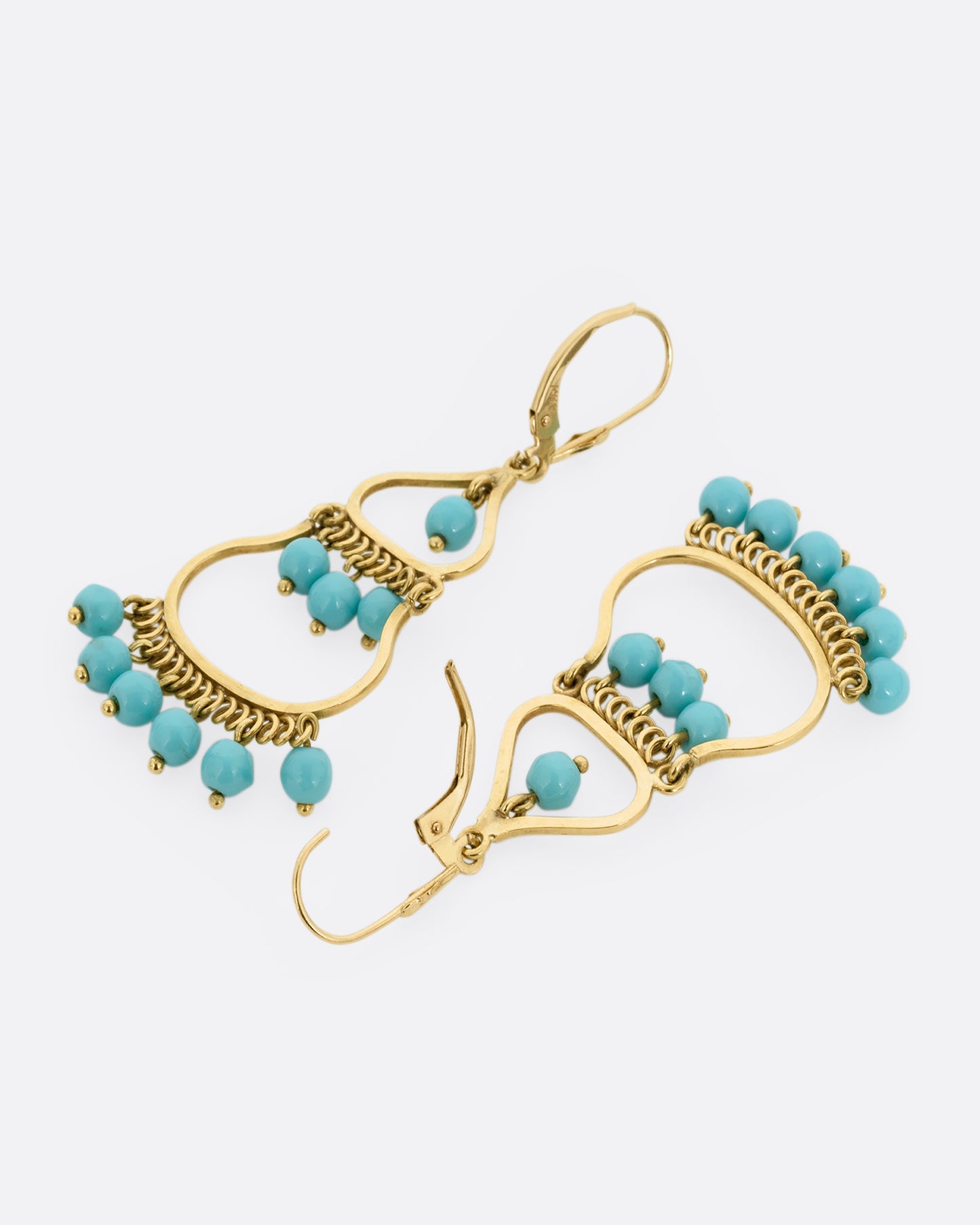 A pair of yellow gold drop chandelier earrings with turquoise beads, shown lying flat from the back. One earring is shown open.