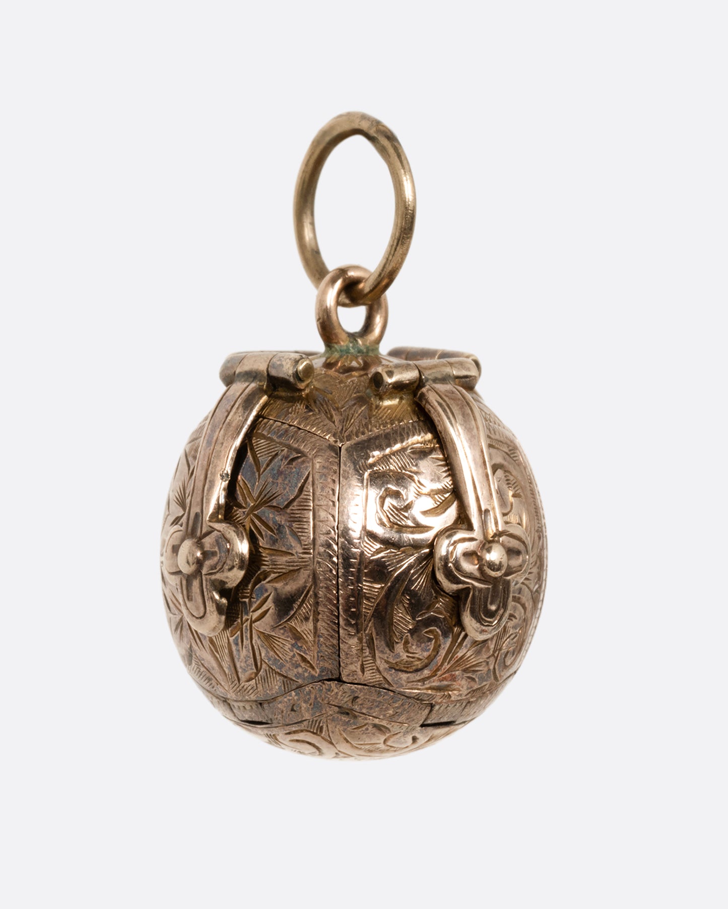 A yellow gold engraved Masonic Orb pendant shown from the side.