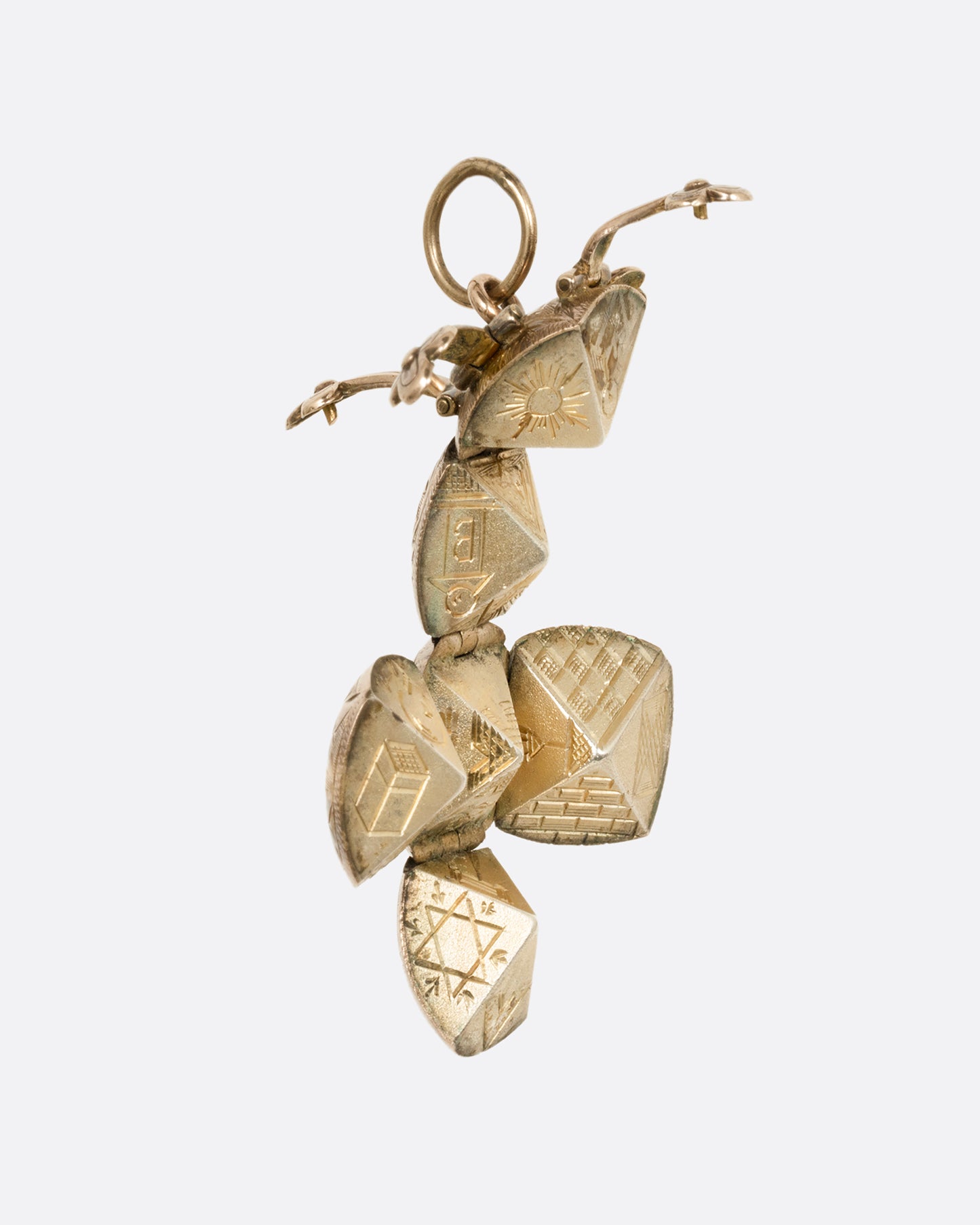 A yellow gold engraved Masonic Orb pendant shown open from the side in a dimensional cross shape.