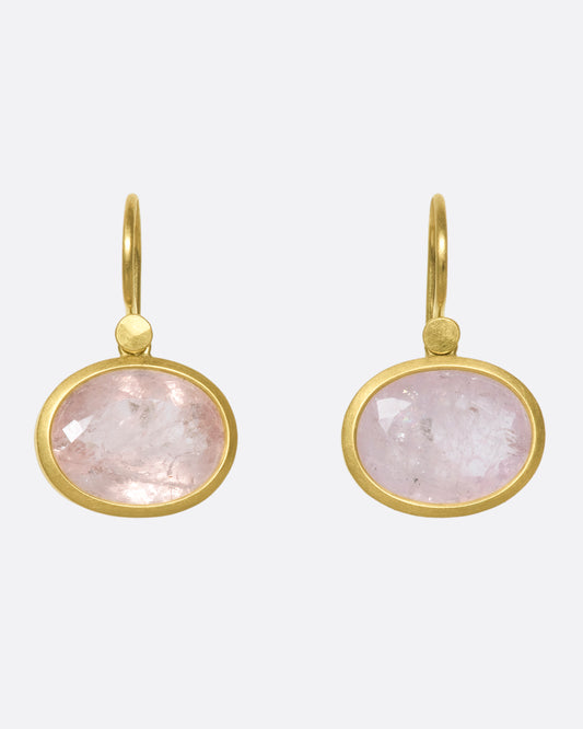 A pair of oval morganite drop earrings with yellow gold bezels and hooks.