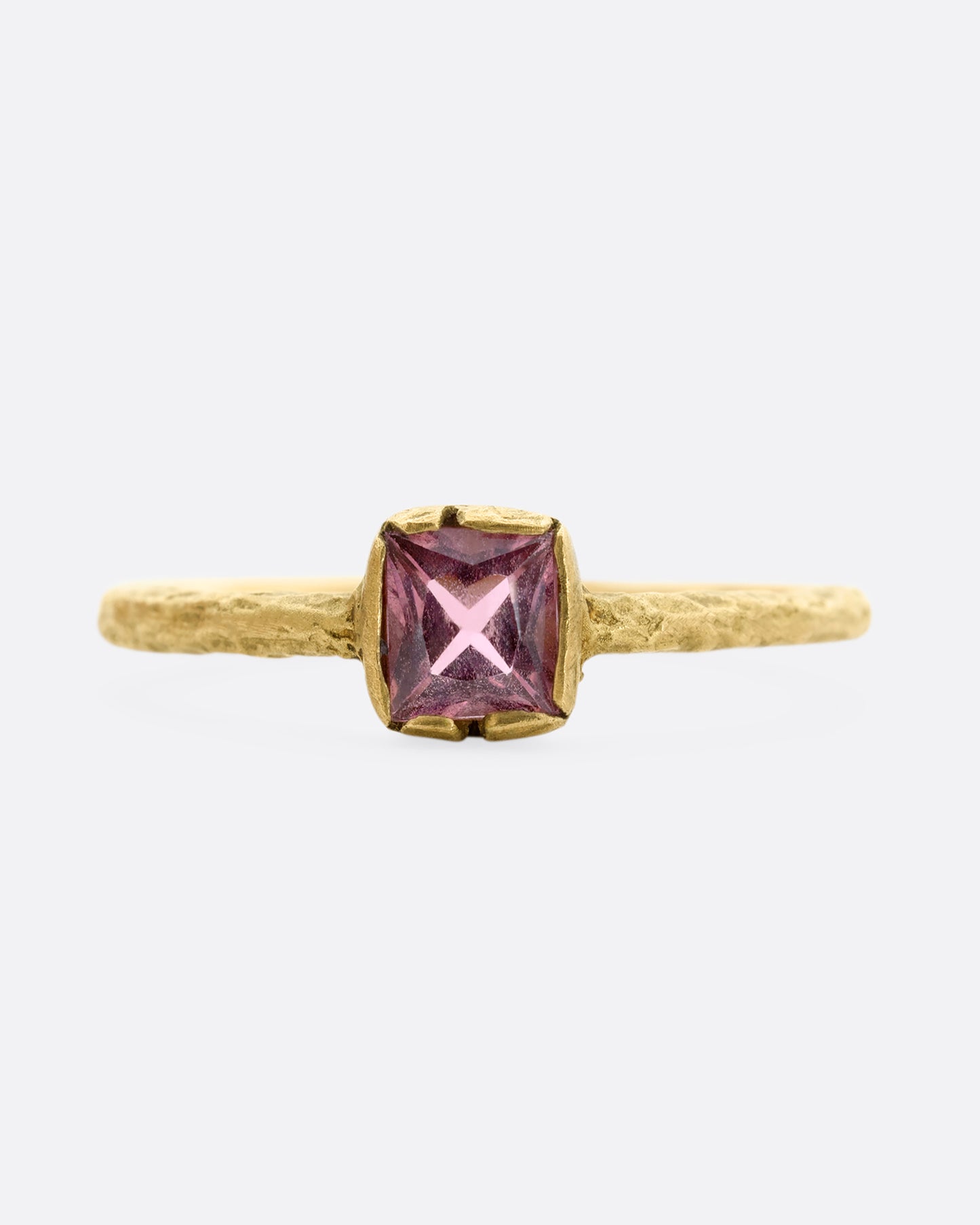 A textured yellow gold ring with a square pink tourmaline. Shown from the front.