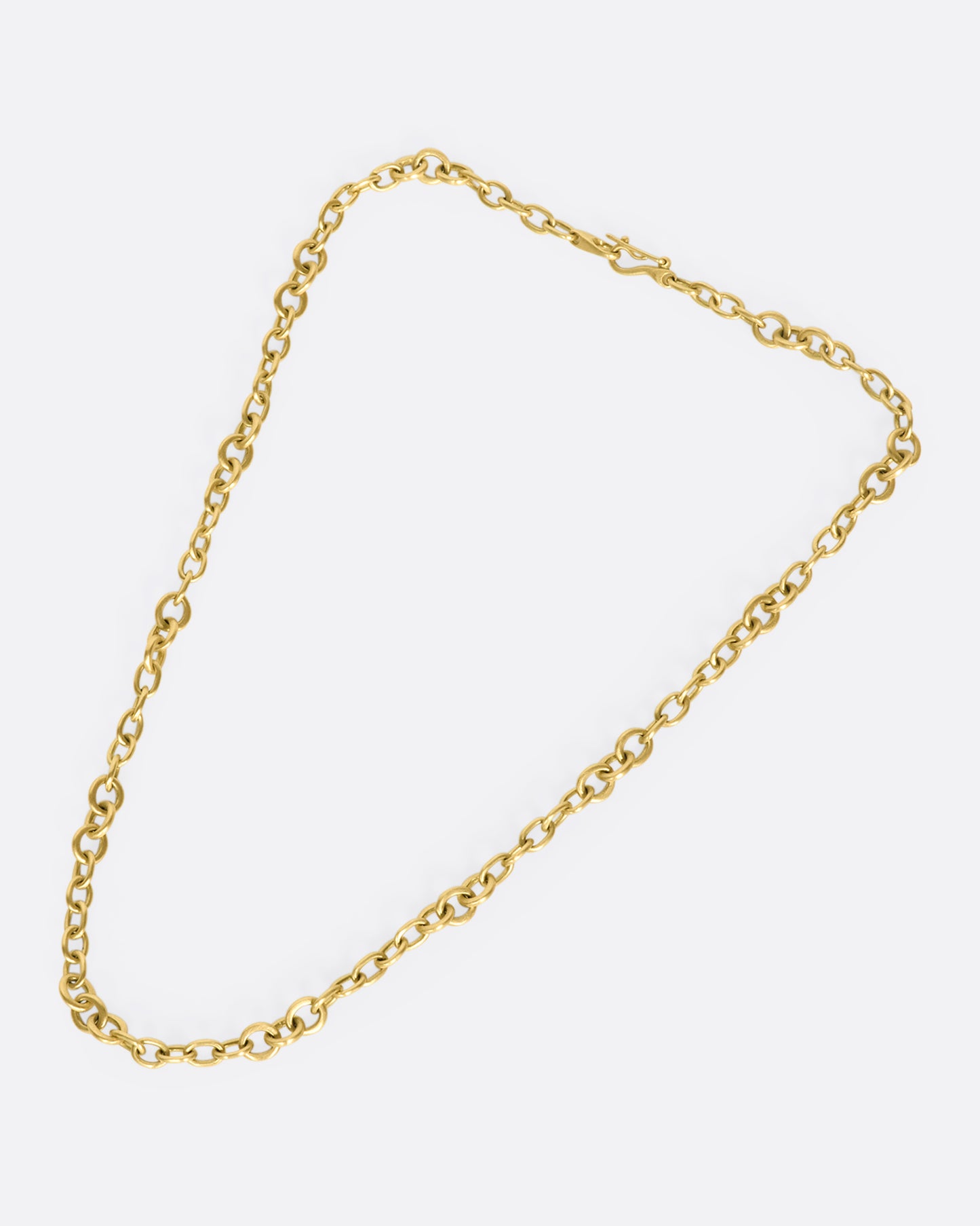 A beautiful 18K gold chain that will rest along your collar bone. Heavy enough to wear on its own in a neck mess and fine enough to add a pendant or two.