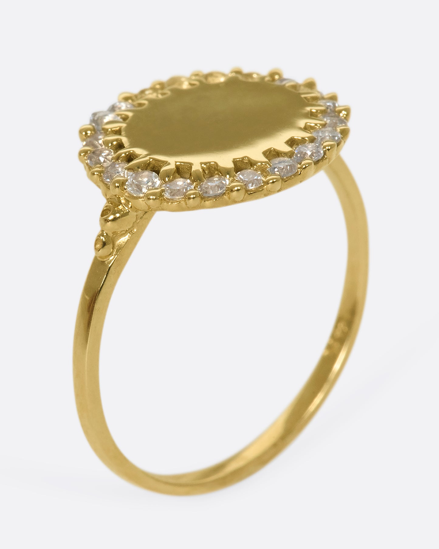 A 14k gold circle ring with a white diamond halo