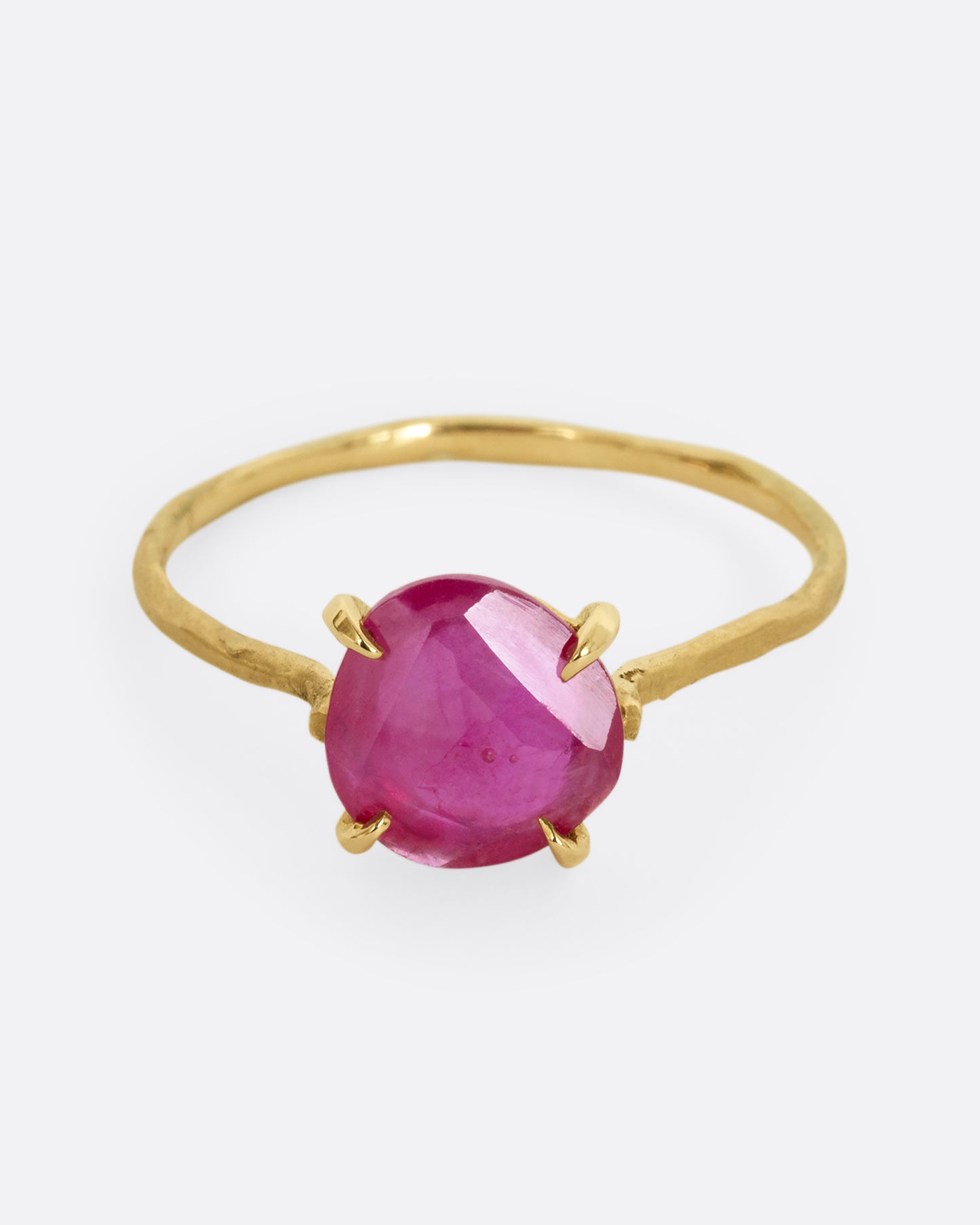 A yellow gold ring with a prong set ruby. Shown from the front.