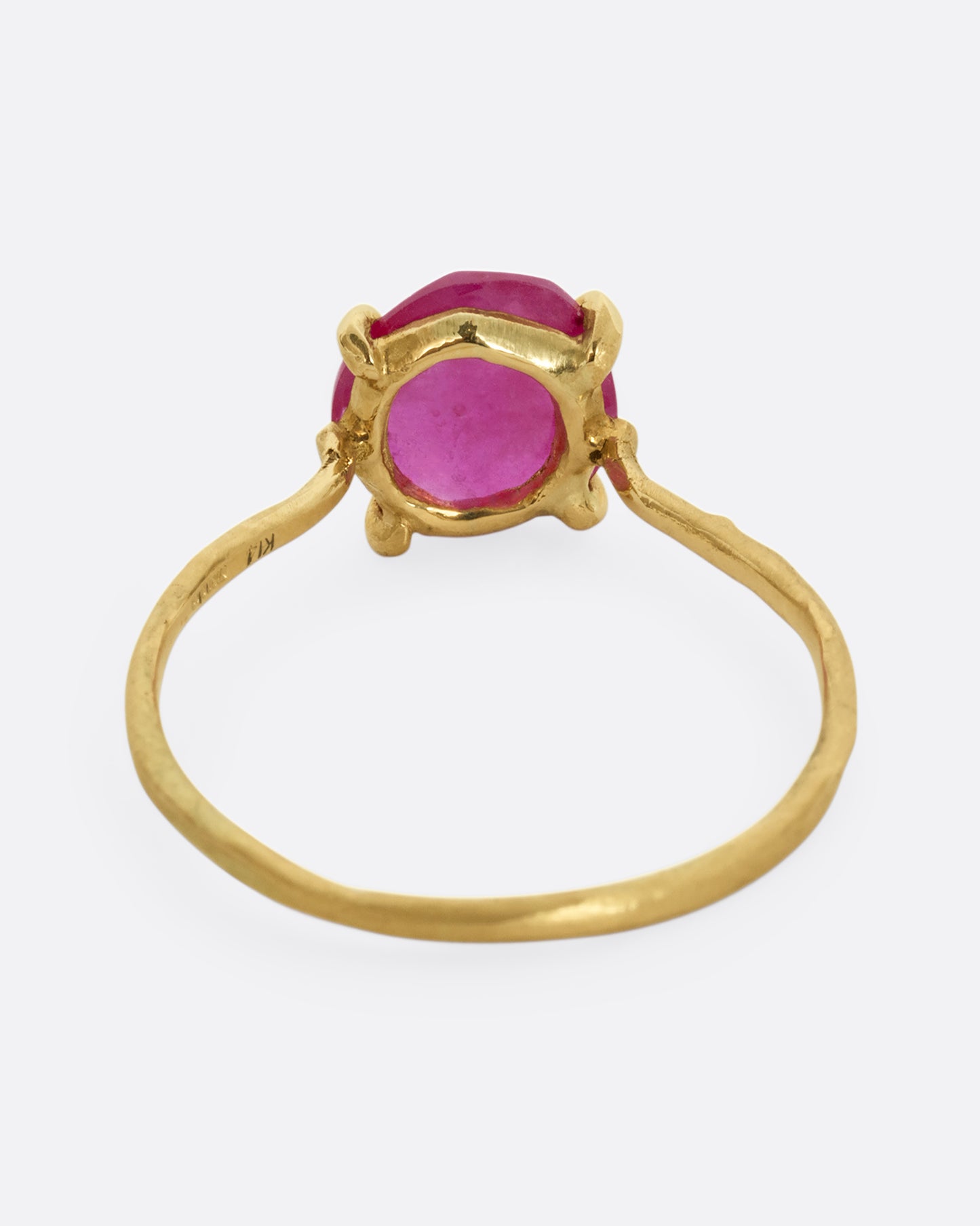 A yellow gold ring with a prong set ruby. Shown from the back.