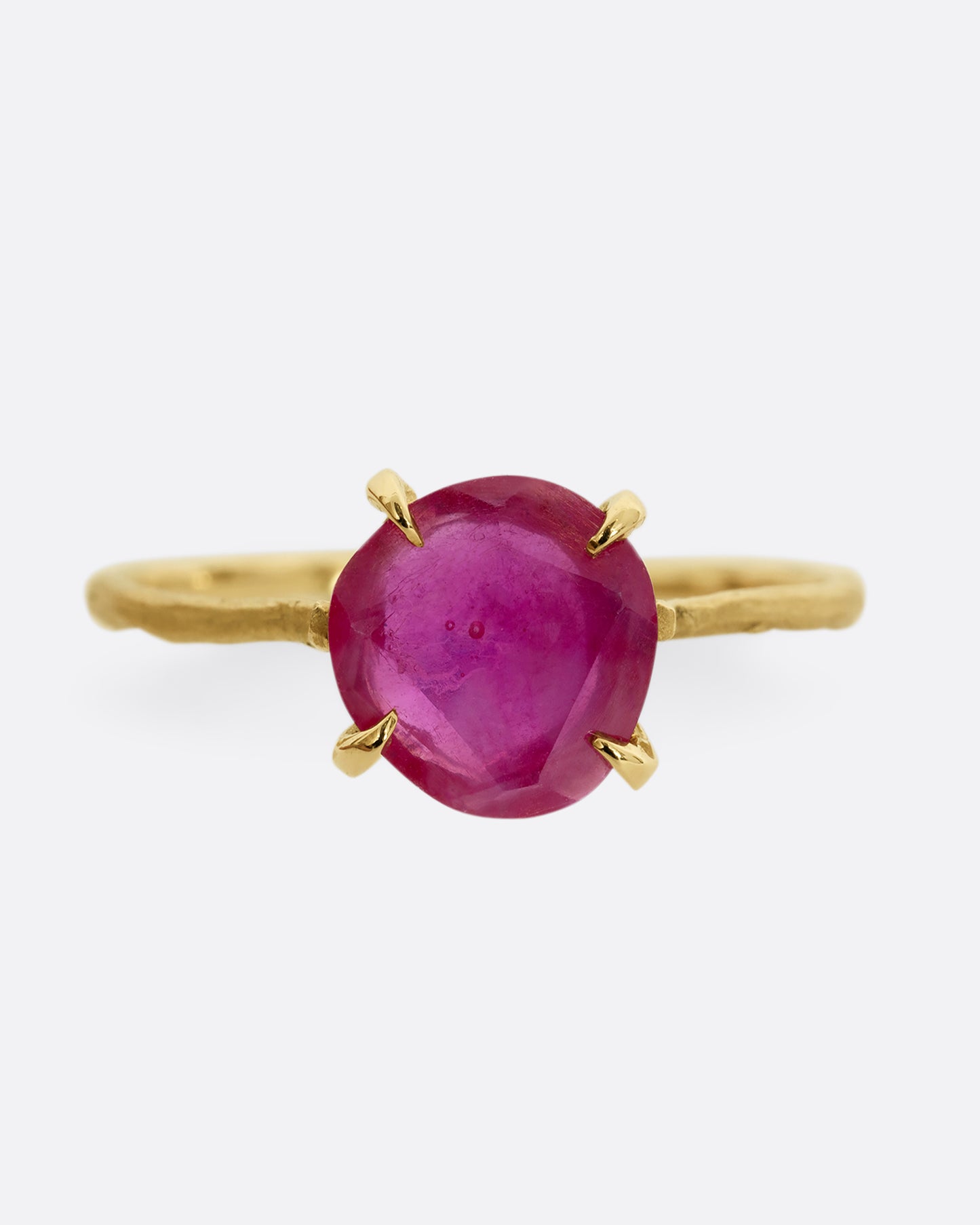 A yellow gold ring with a prong set ruby. Shown from the front.