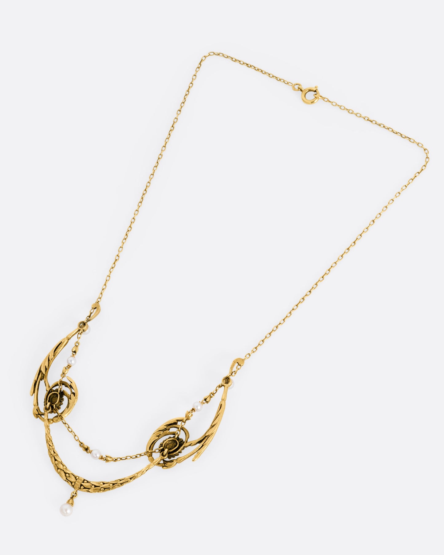 A yellow gold necklace with pearls and flower details, shown from the front.