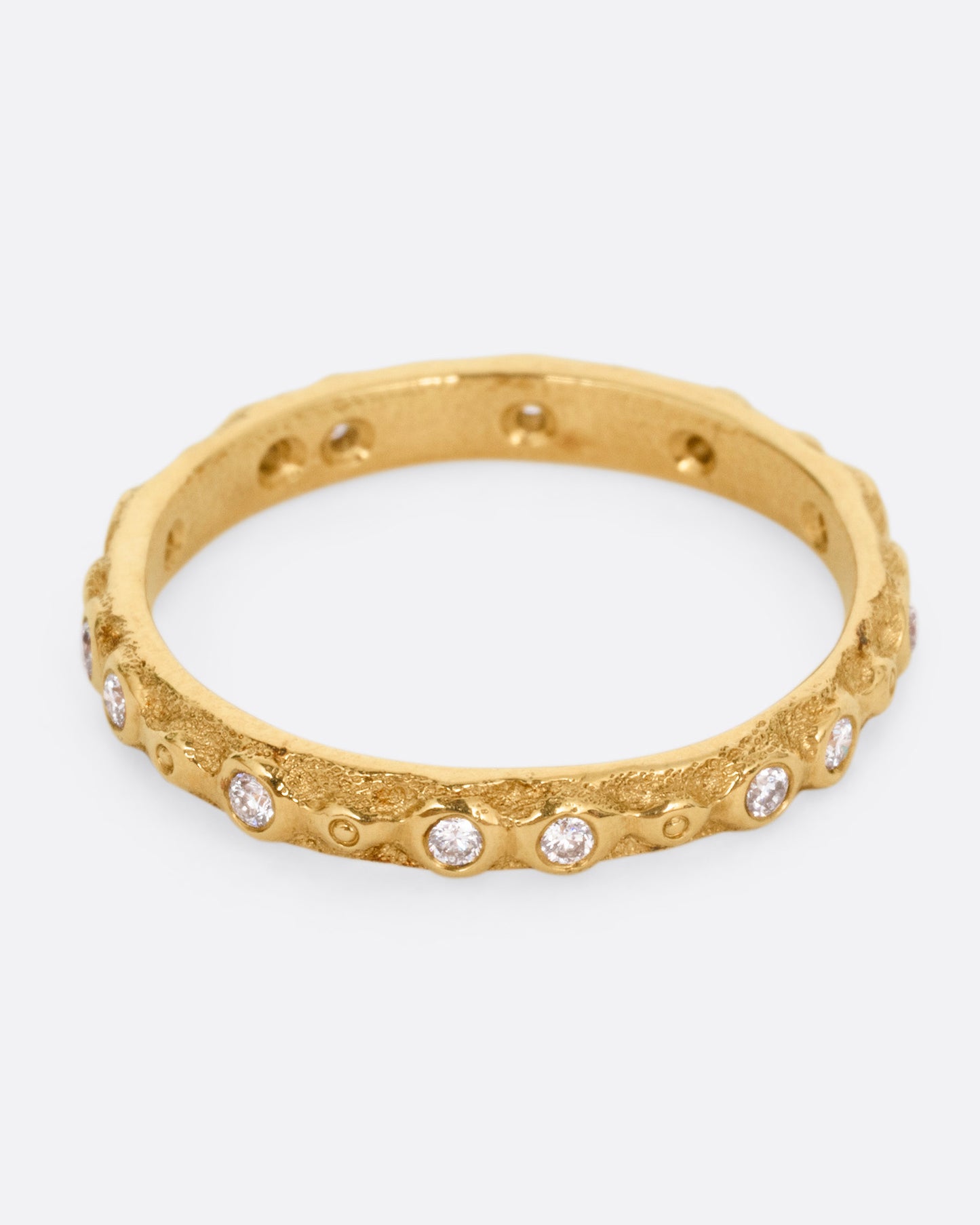 A textured yellow gold ring with white diamonds. Shown from the front.