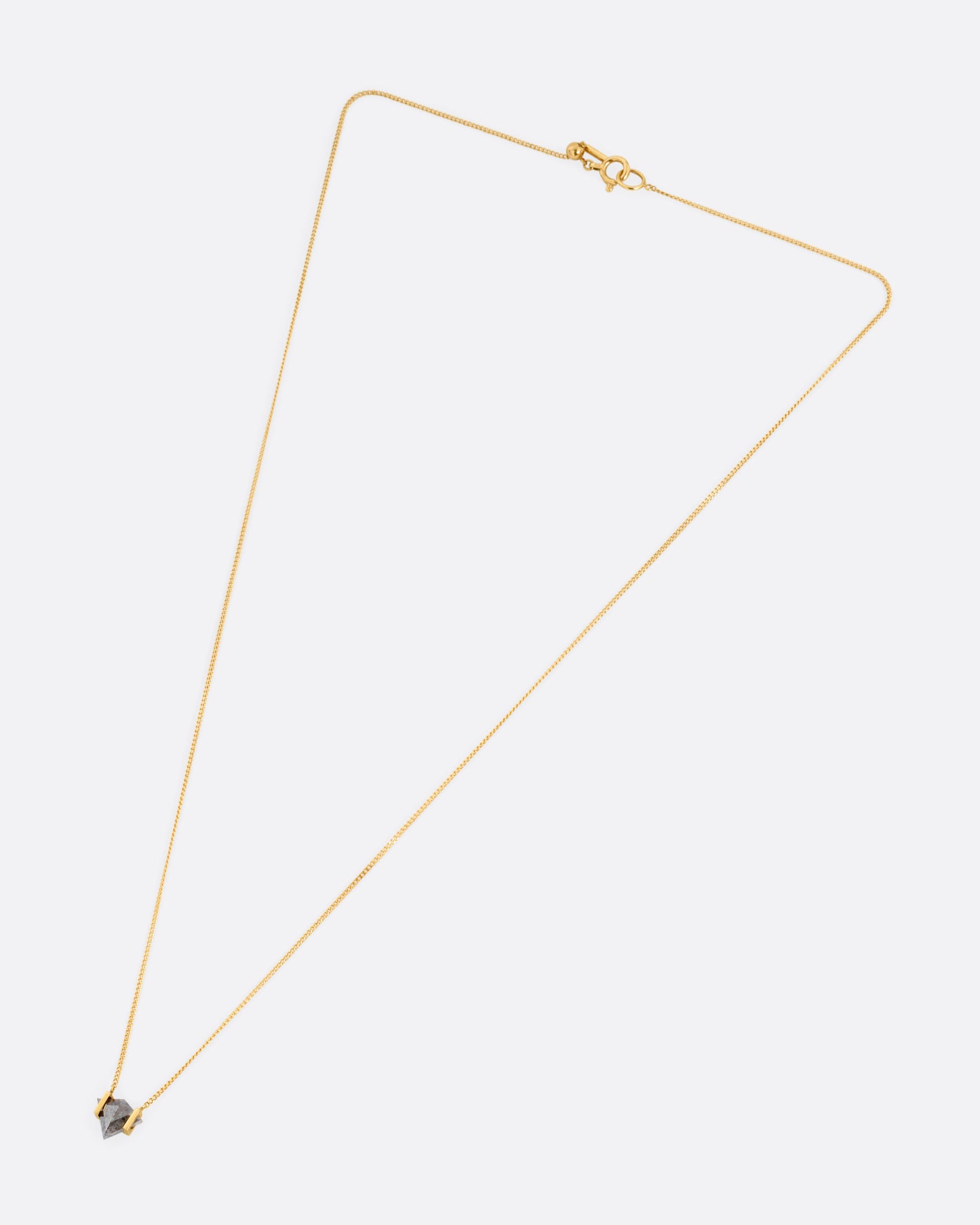 A yellow gold necklace with a salt and pepper diamond pendant, shown from the front.