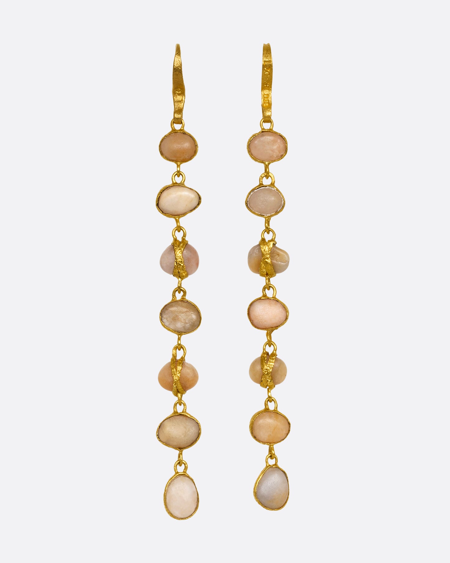 A pair of earrings with seven river pebbles, each wrapped in yellow gold hanging from yellow gold ear hooks. Shown from the front.