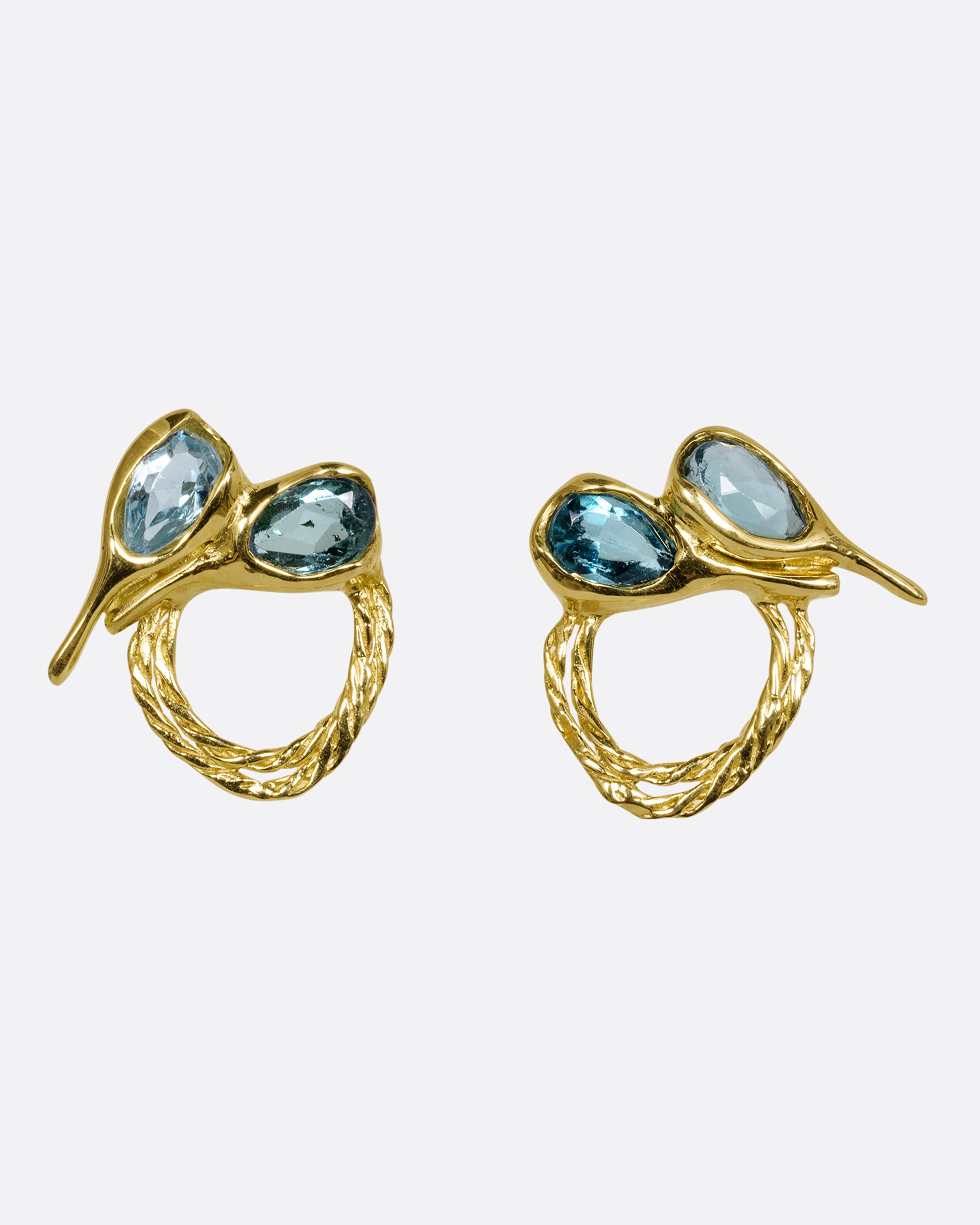 A pair of yellow gold stud earrings with two free- form blue green tourmalines and textural hoops. Shown from the front.