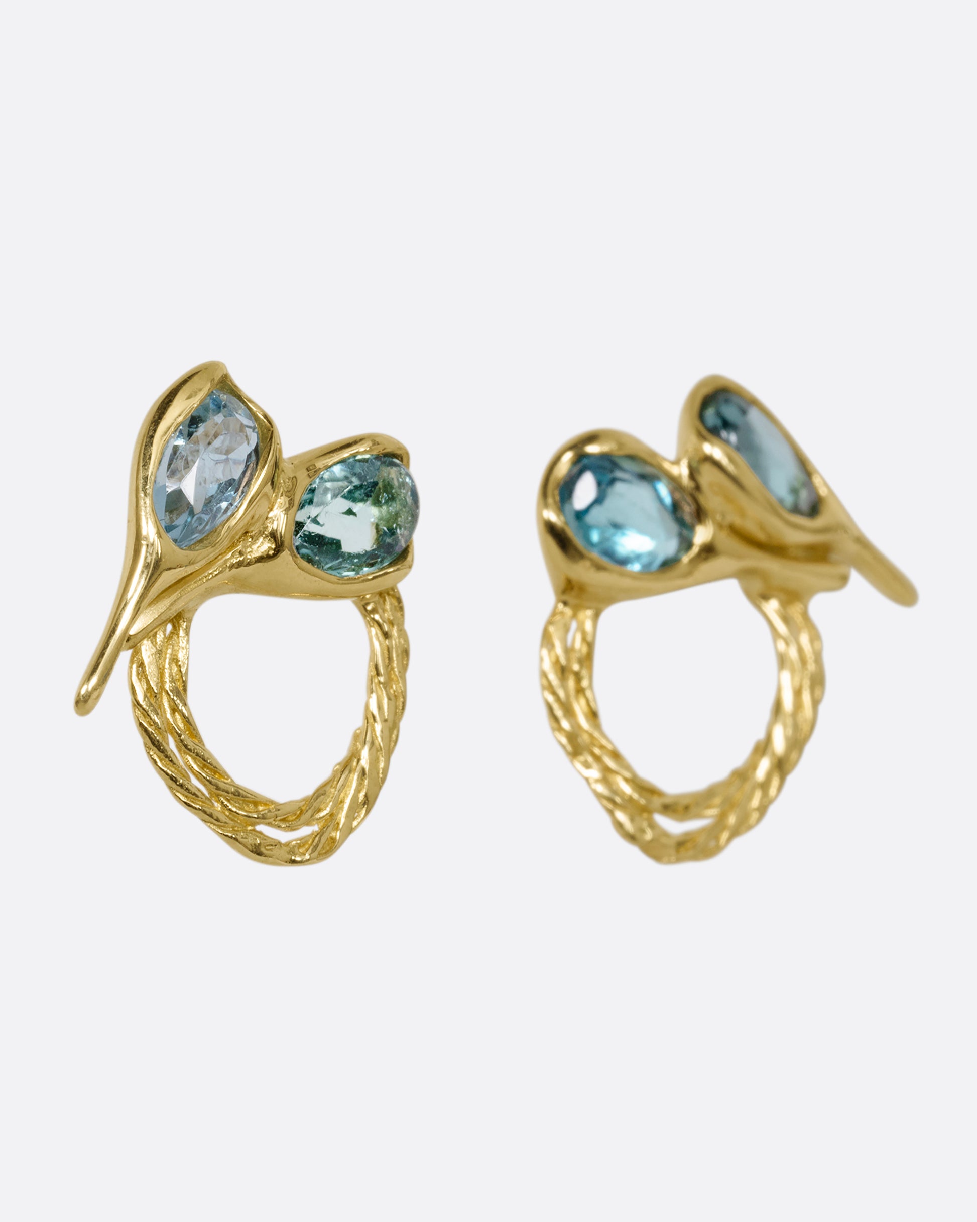 A pair of yellow gold stud earrings with two free- form blue green tourmalines and textural hoops. Shown at an angle from the front.