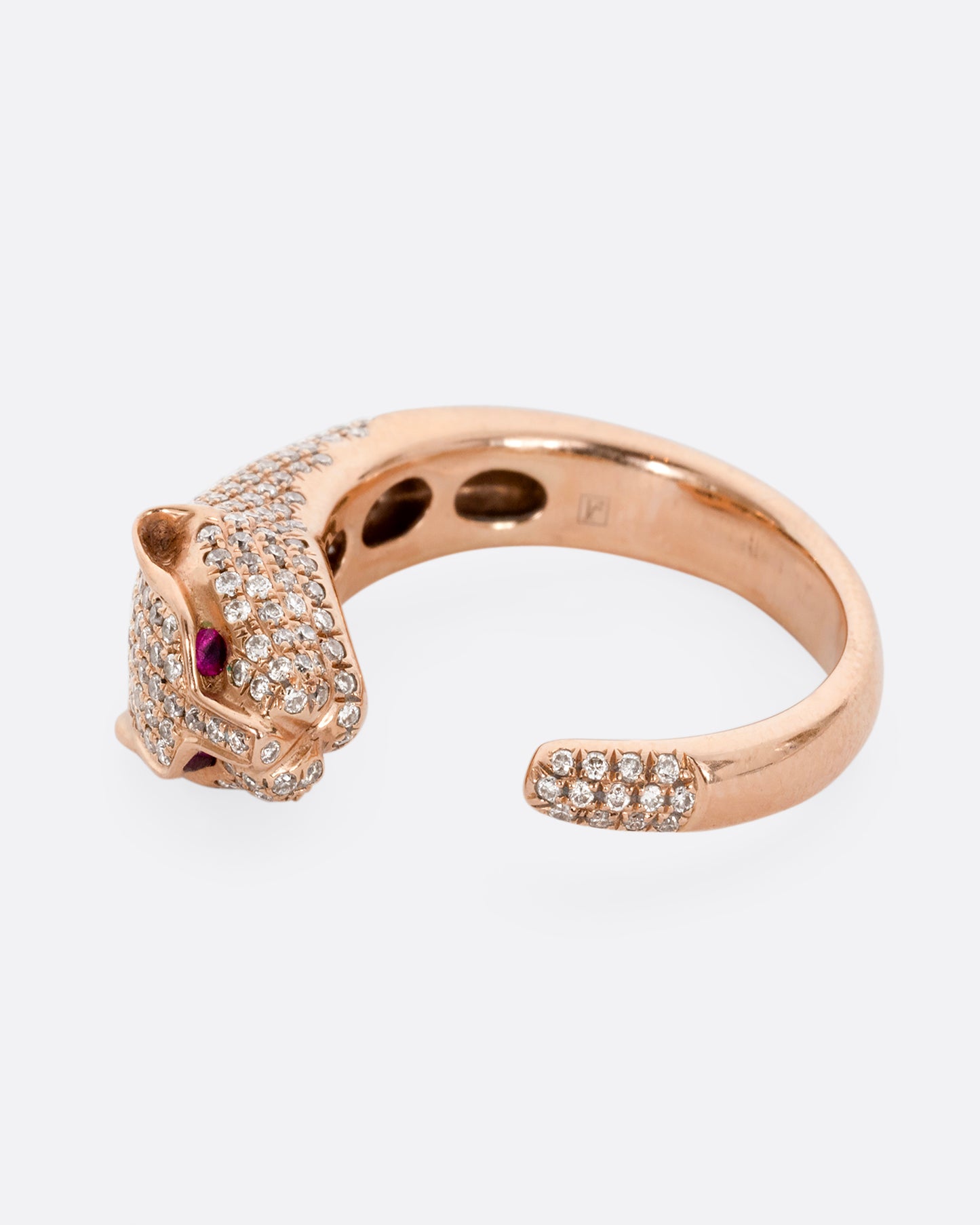 A rose gold panther wrap ring with pave diamonds on the head and tail and ruby eyes. Shown from the side.