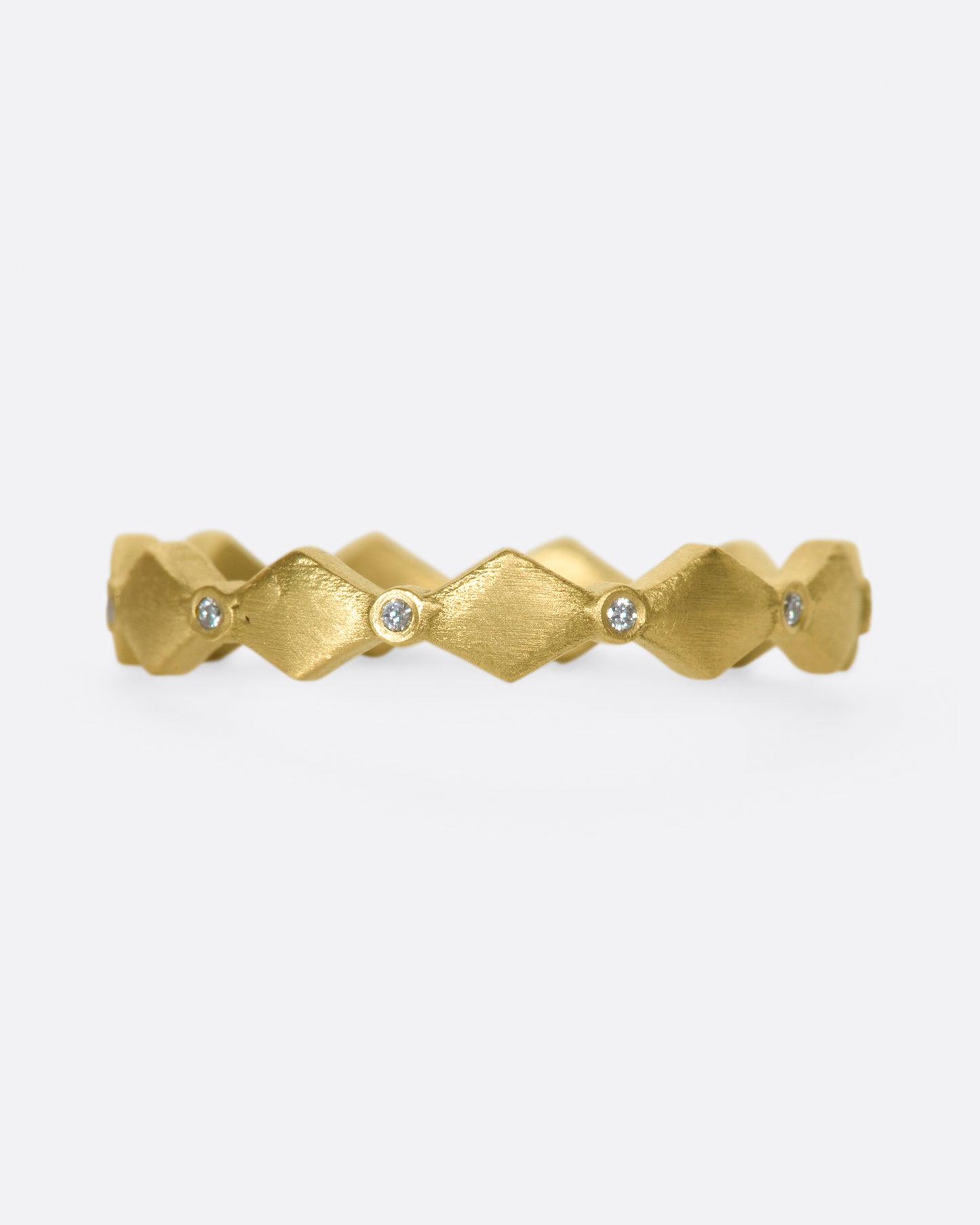 A geometric band with alternating round diamonds and matte gold shapes.