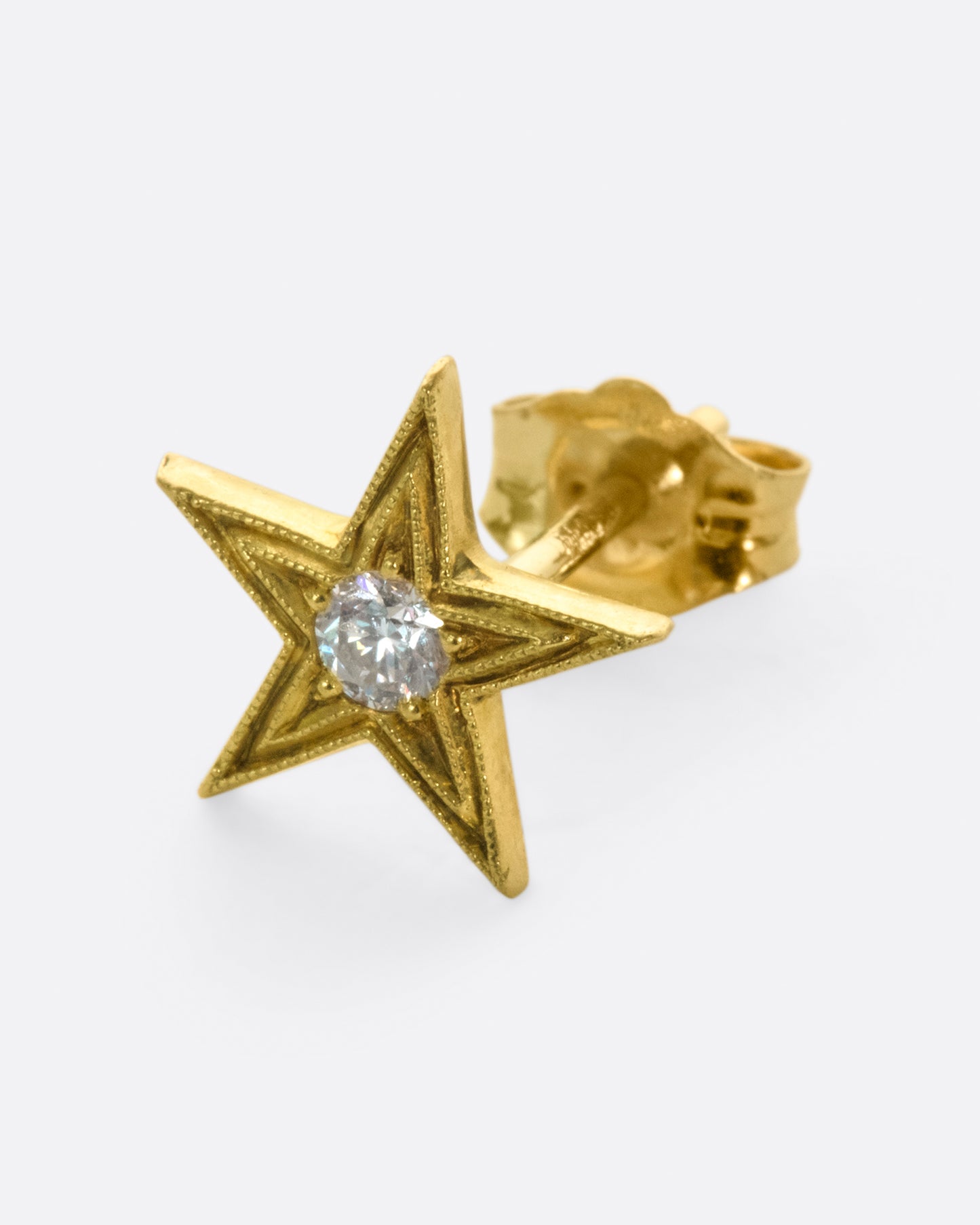This earring is one of the many varieties of stars in Anthony Lent's work, this time a bit larger and more traditional.