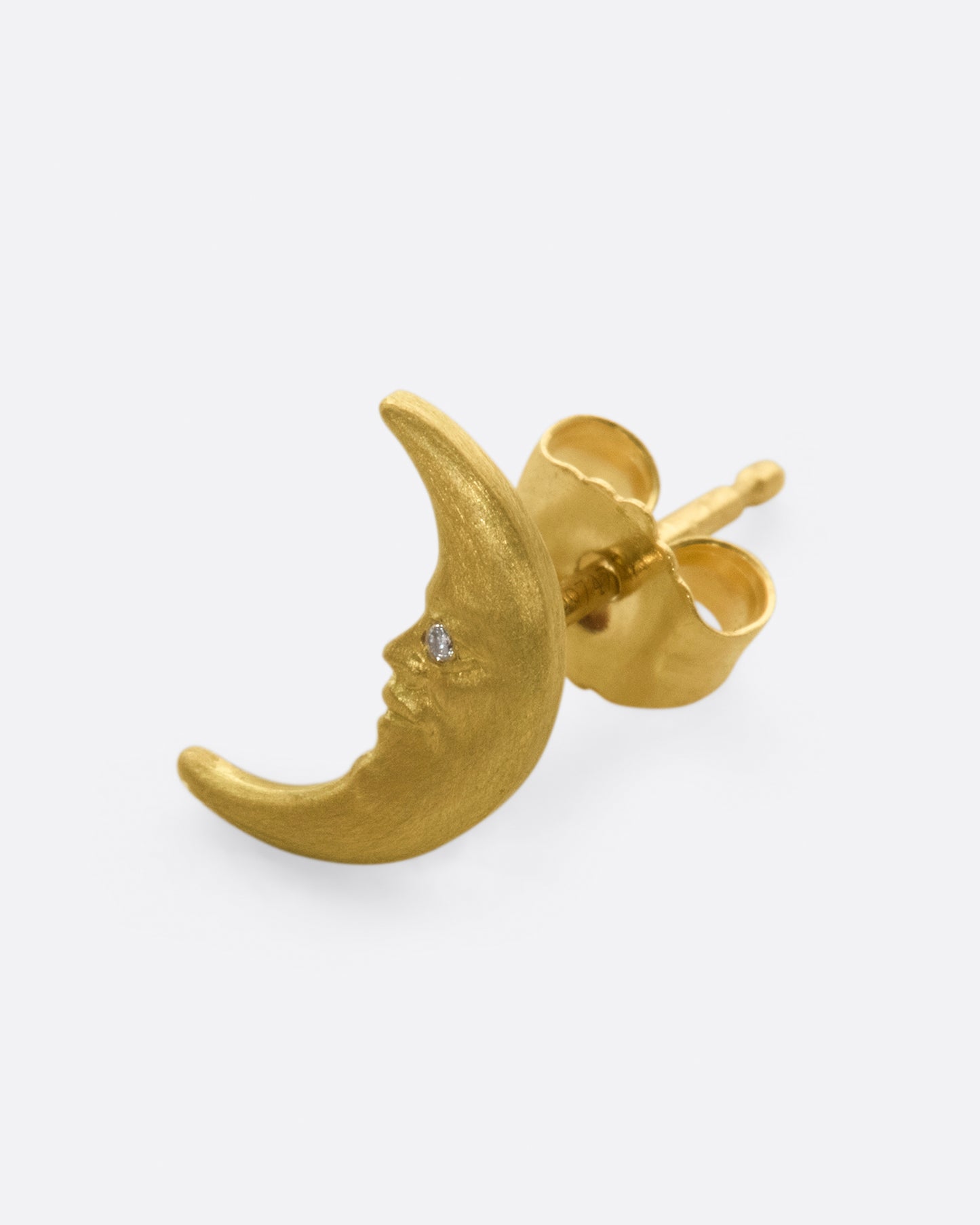 A yellow gold crescent moon stud earring with a face and a diamond eye. Shown diagonally from the front.