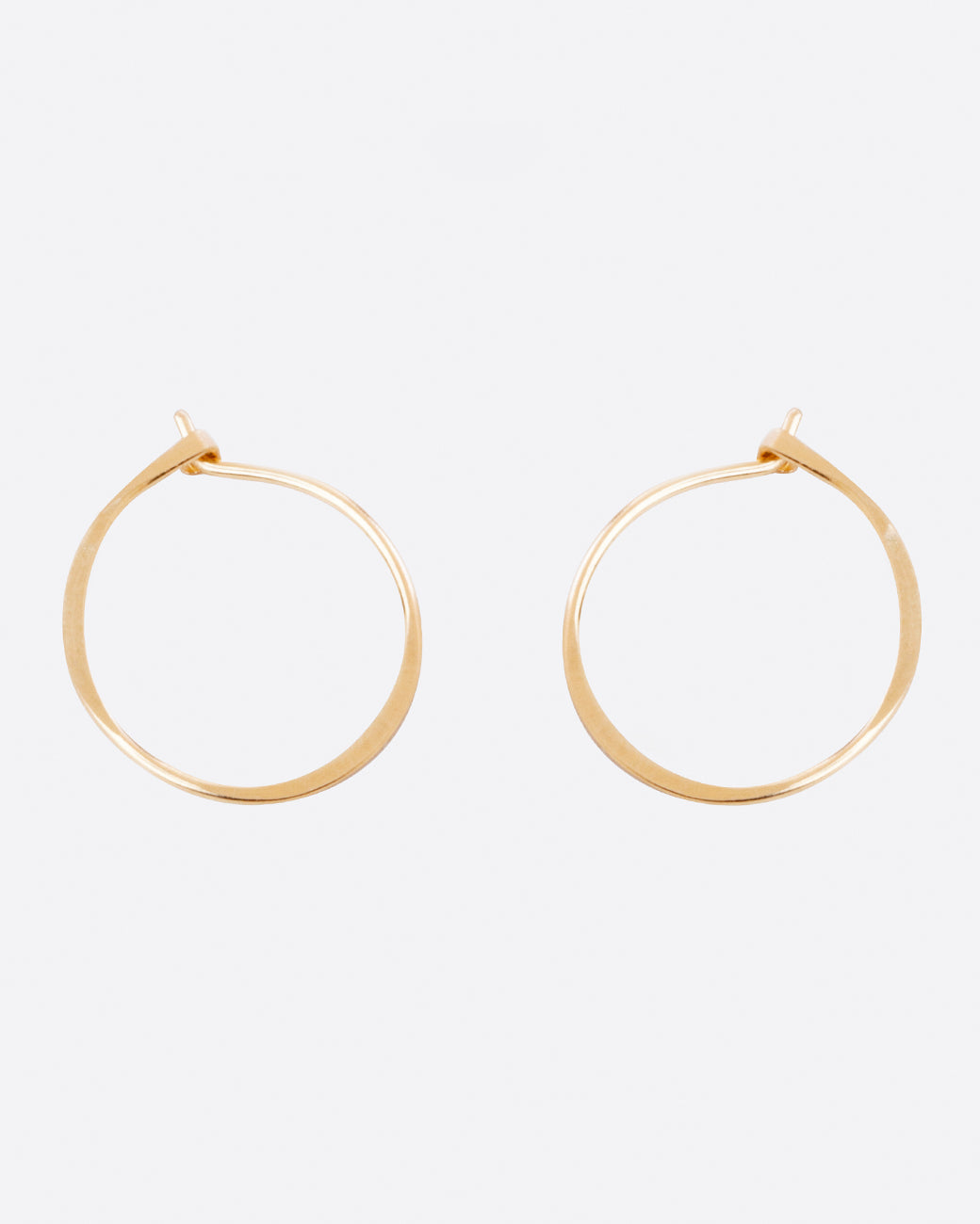 Gold wire small round hoop earrings, the pair laid flat