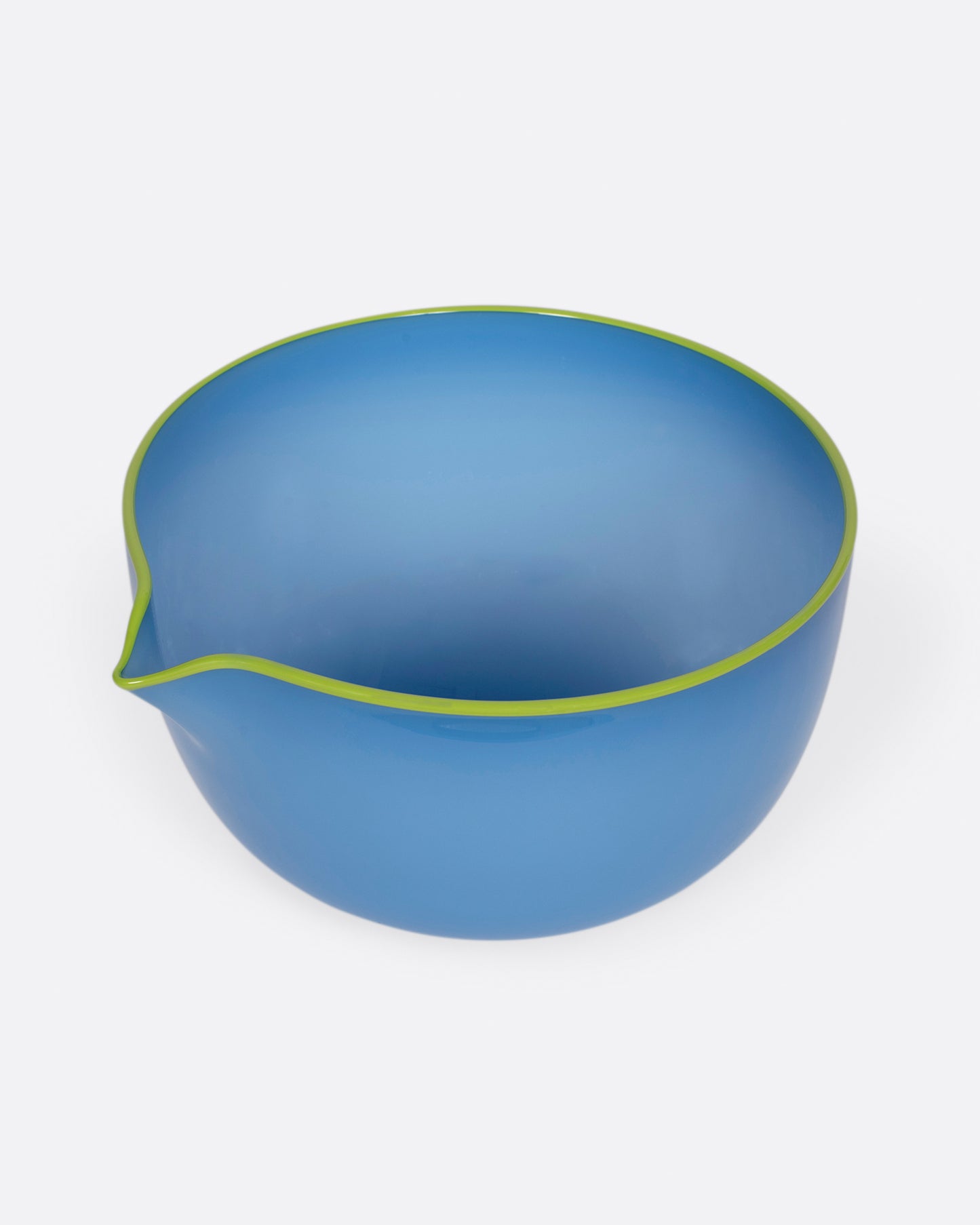 A hand blown blue glass spouted bowl with a chartreuse edge. Shown from the top.