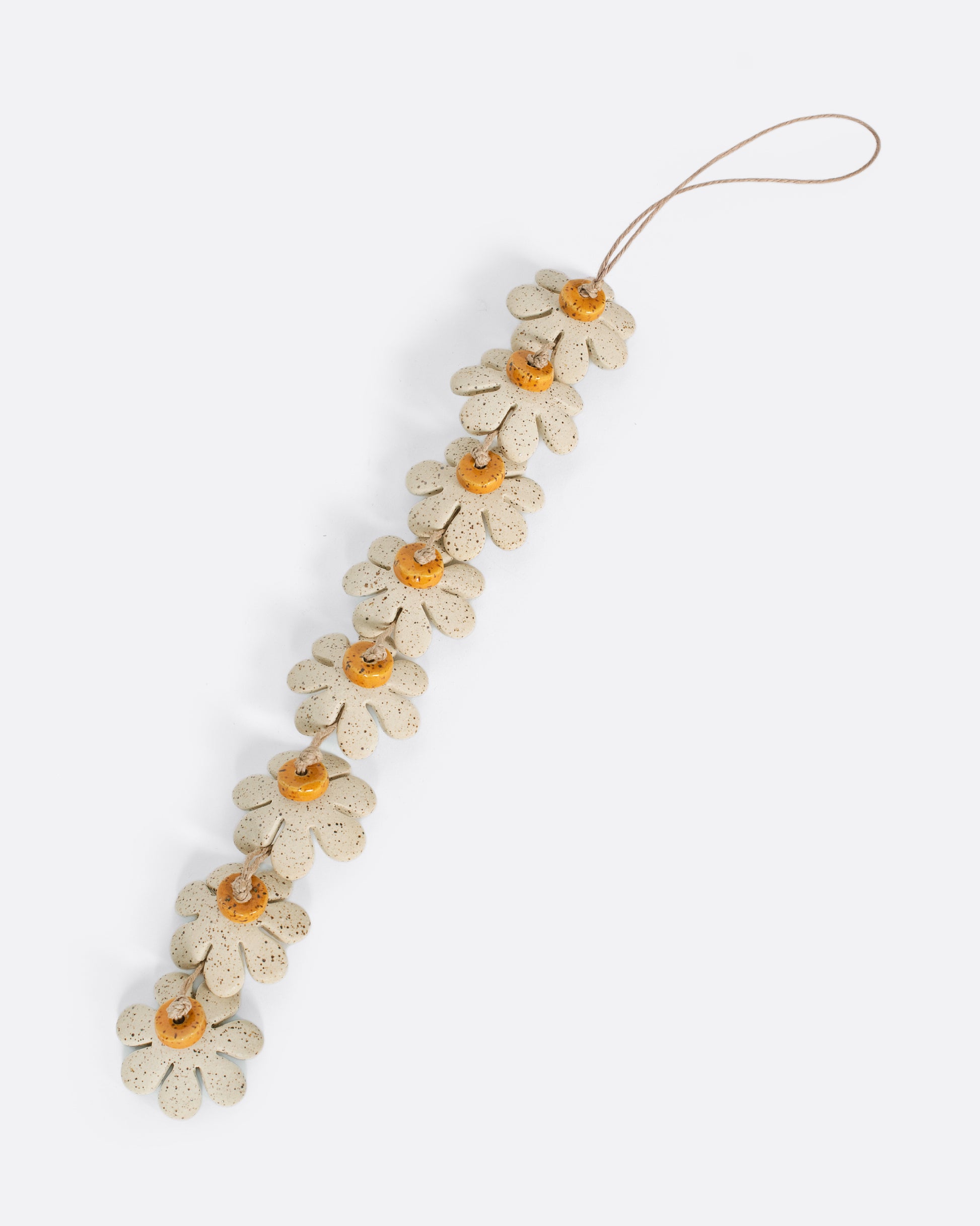 This daisy chain ceramic garland adds a burst of sunshine to any corner, window, or kids room. They look especially sweet hanging in a cluster like a mobile over a crib.