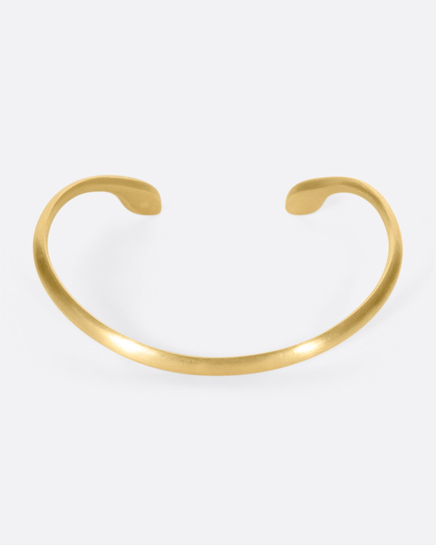 Almost snake-like in shape and gesture, this open cuff bracelet is solid and punctuated with gray diamonds.