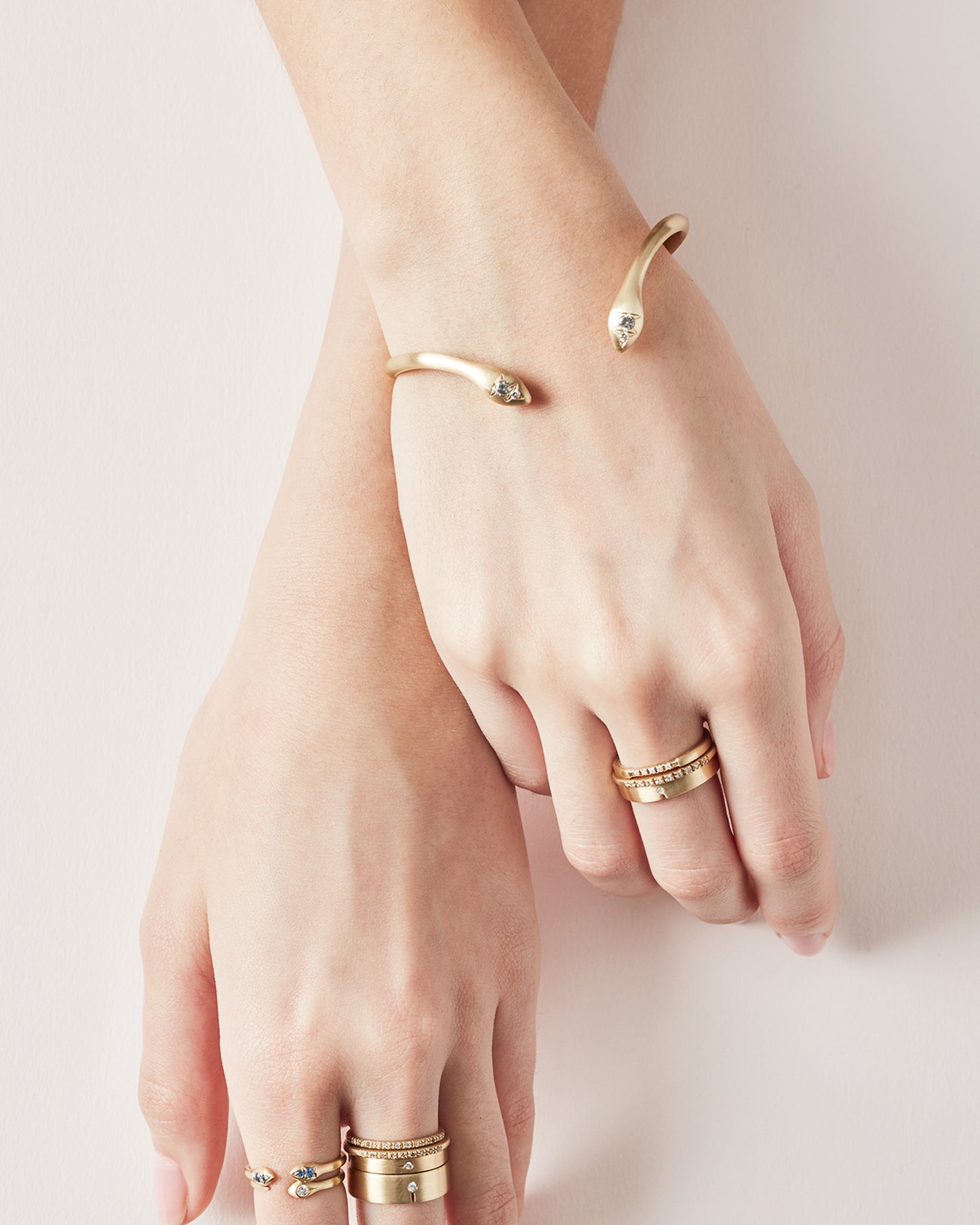 Almost snake-like in shape and gesture, this open cuff bracelet is solid and punctuated with gray diamonds.